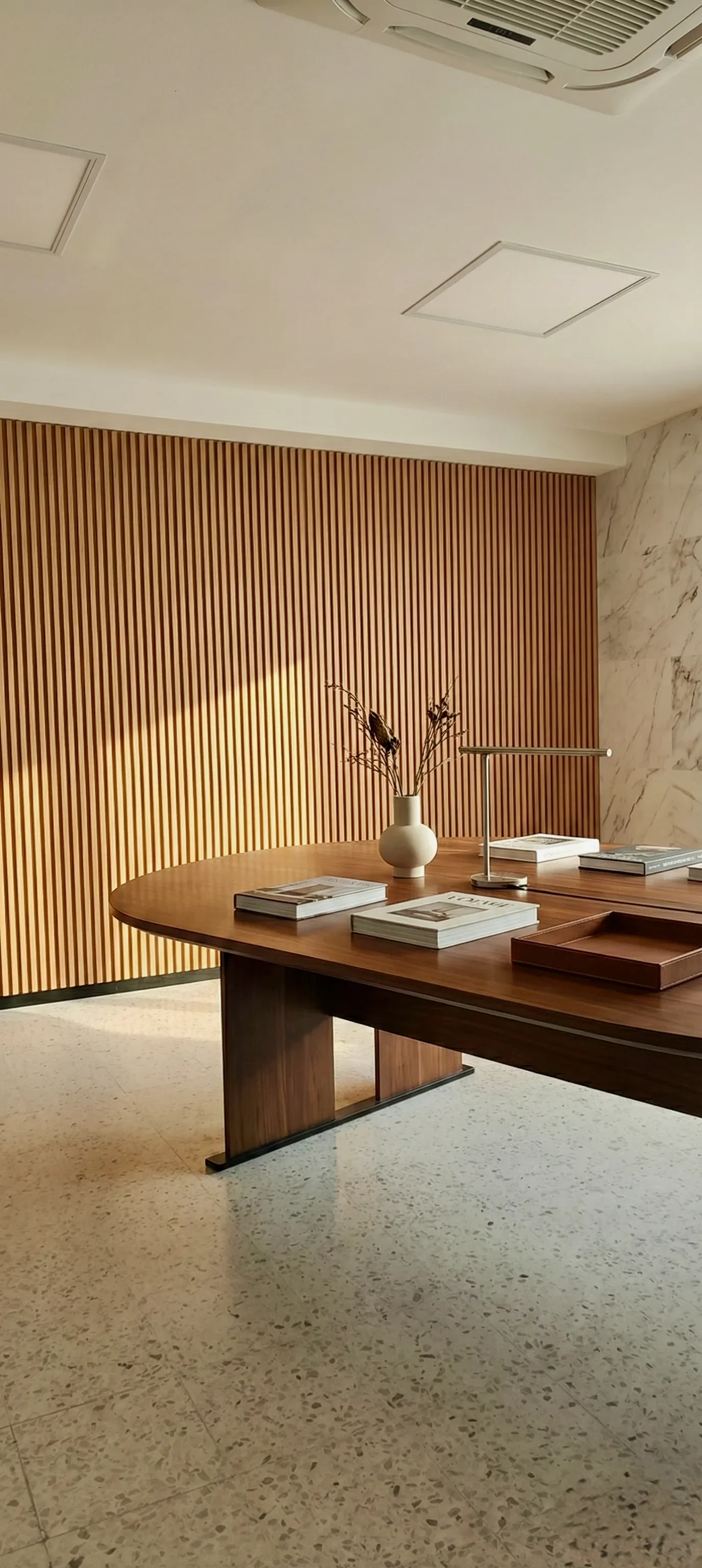 Revestimiento de muro interior con lambrín de WPC (madera compuesta) acanalado en sala de juntas ejecutiva. Acabados arquitectónicos de bajo mantenimiento y estética cálida para espacios corporativos en Oaxaca.