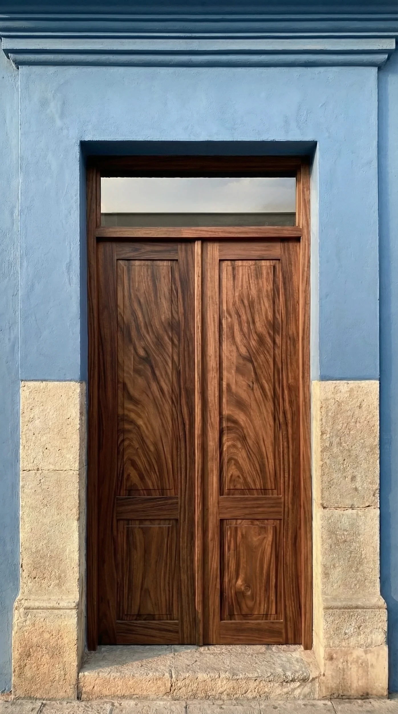 Puerta principal de dos hojas en madera sólida de Tzalam fabricada por Estudio Madera, integrada en fachada colonial del centro de Oaxaca.