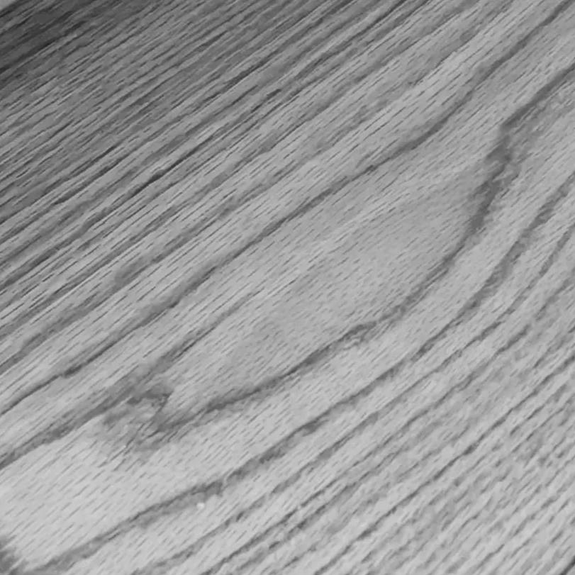 Detalle macro circular de veta de madera de Pino en tonos claros y naturales. Una textura que representa la honestidad material y el minimalismo cálido de Estudio Madera.