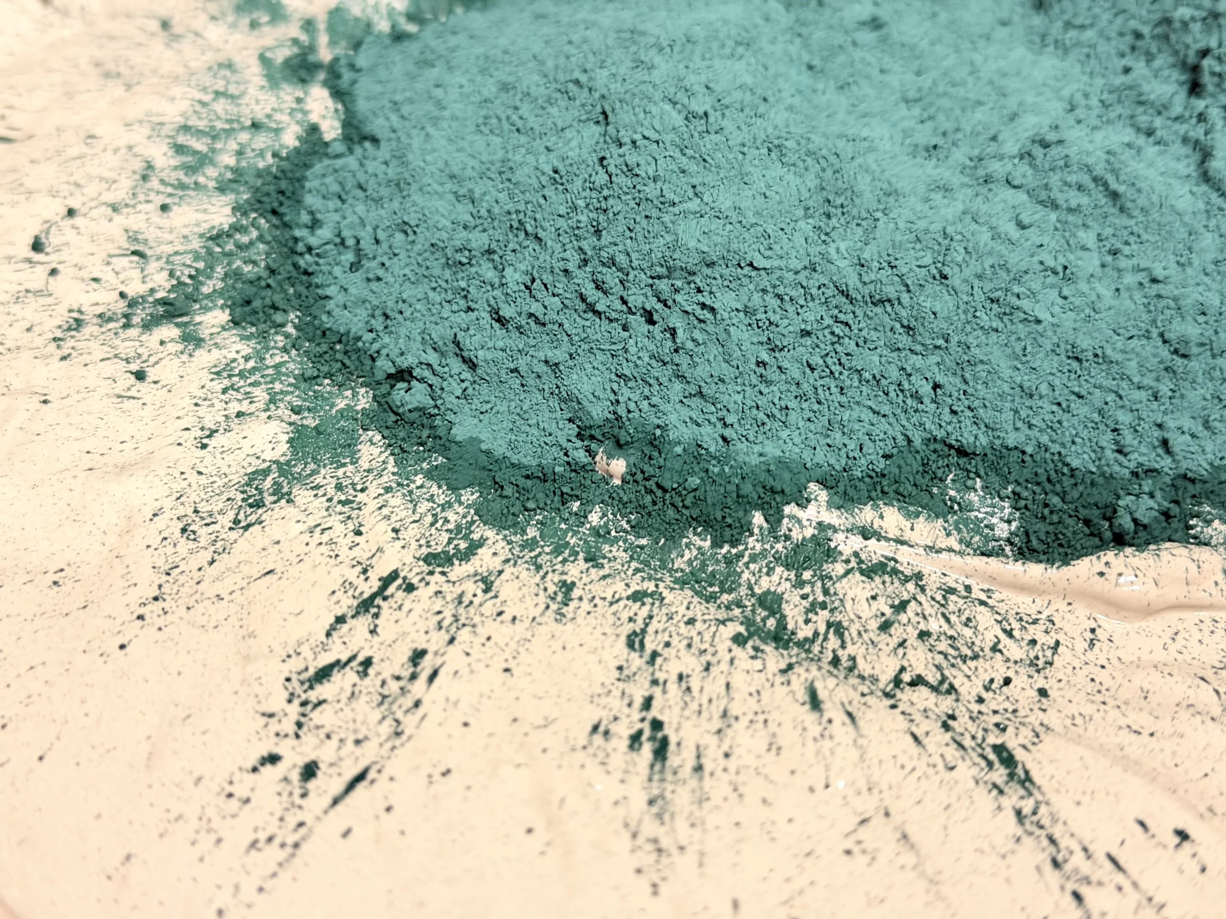 Close-up of green powdered pigment spread on a surface with fine details.