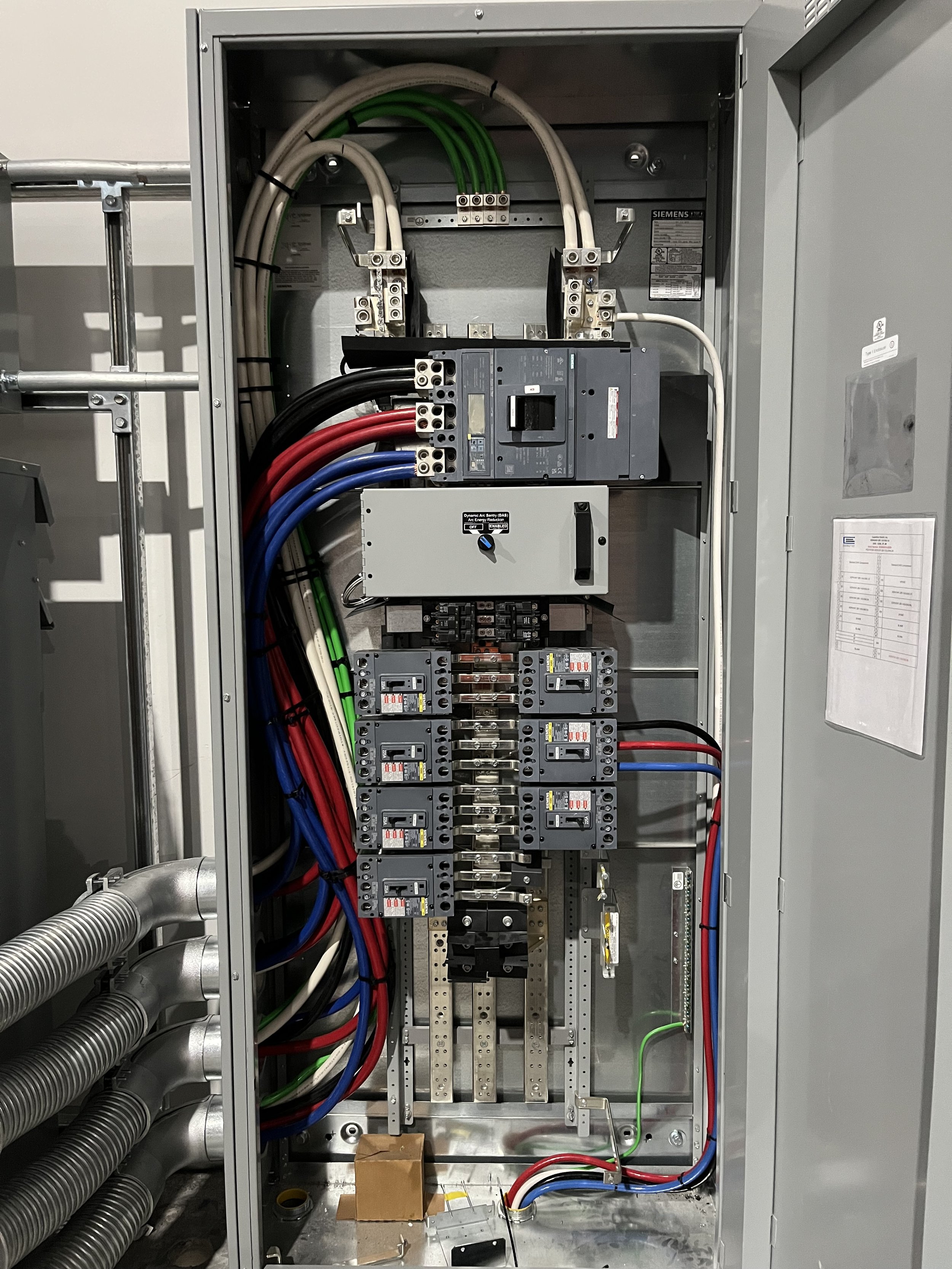 Interior of an electrical panel with circuit breakers, wiring, and other electrical components.