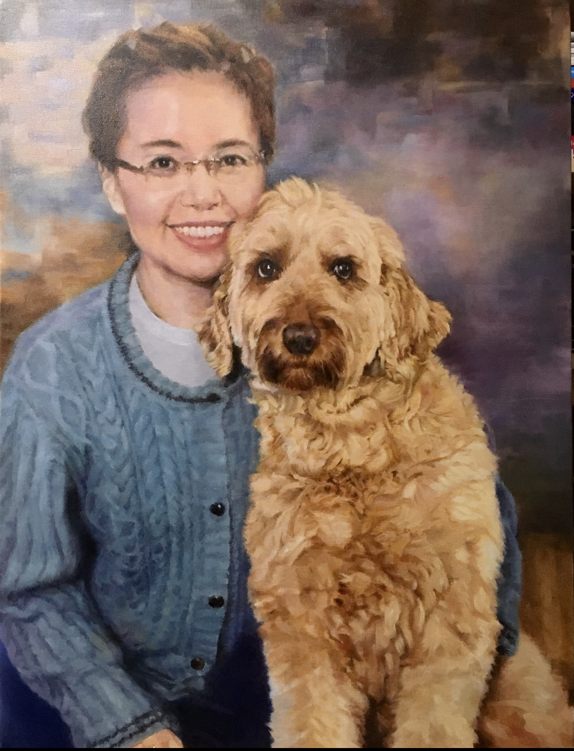 A woman with short brown hair and glasses smiling next to a large, curly-haired golden-colored dog.