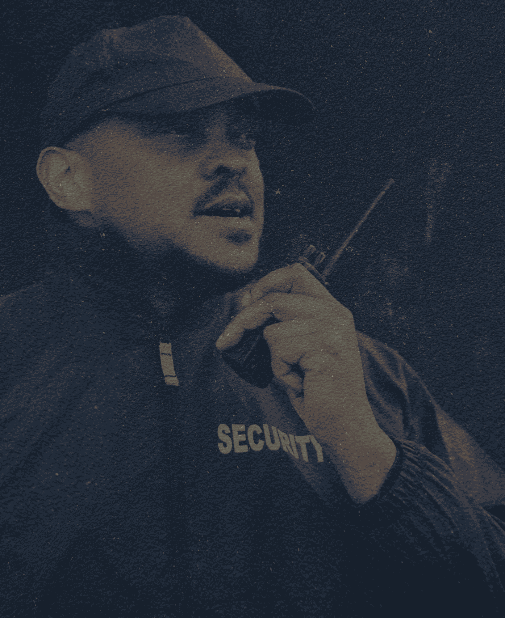 A security guard wearing a hat and uniform, holding a radio, with the word 'SECURITY' visible on the uniform.