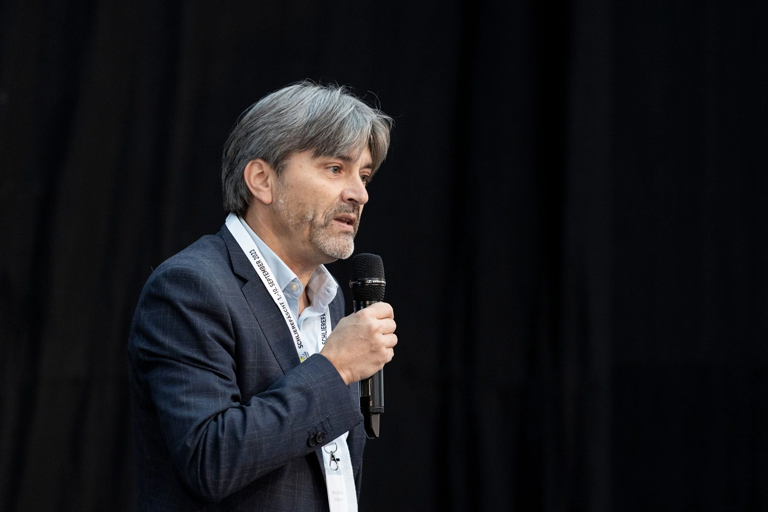 Stadtpräsident Markus Bärtschiger hält eine Rede mit einem Mikrophon.