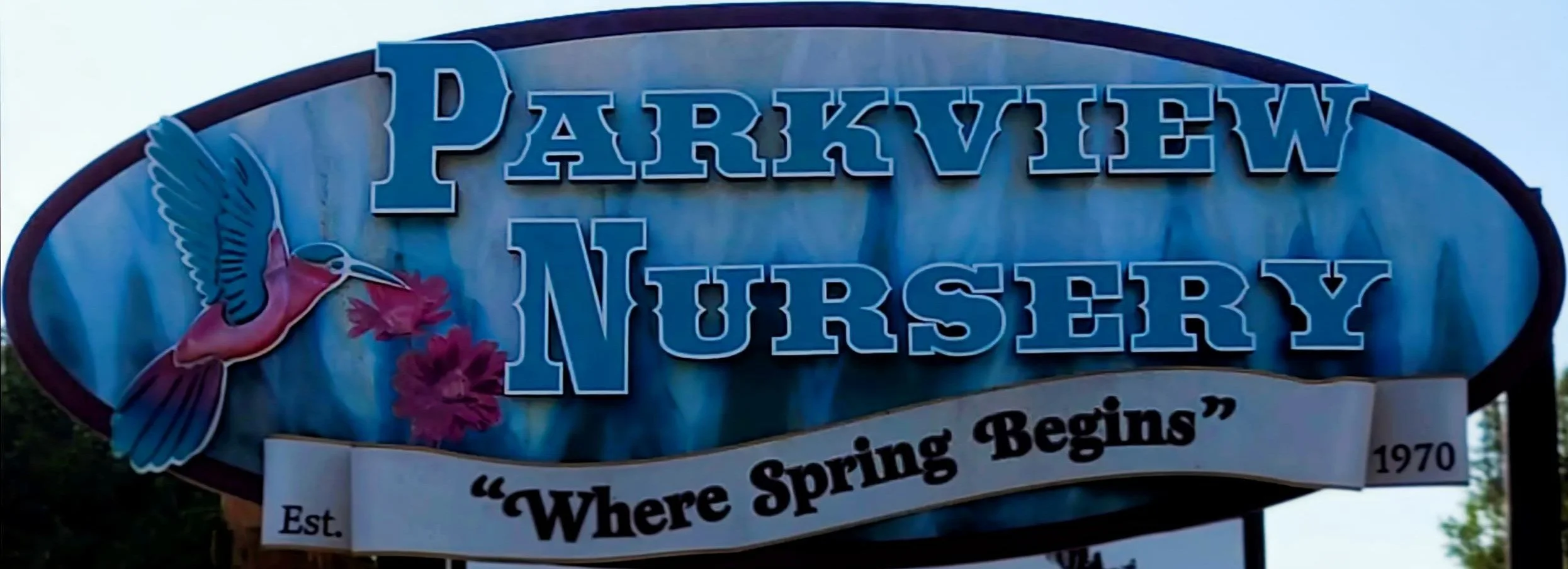 Sign for Parkview Nursery featuring a hummingbird and pink flowers, with the motto 'Where Spring Begins', established in 1970.