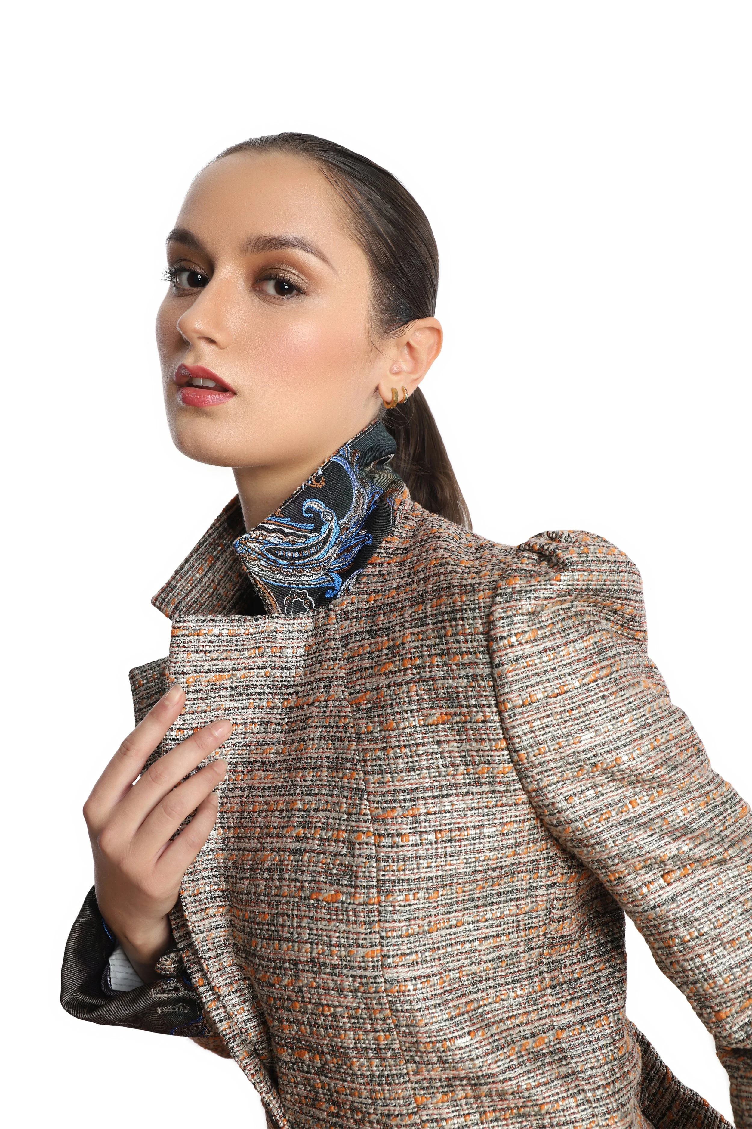 Close up of model wearing a silver tweed blazer with blue paisley print on the under collar. 