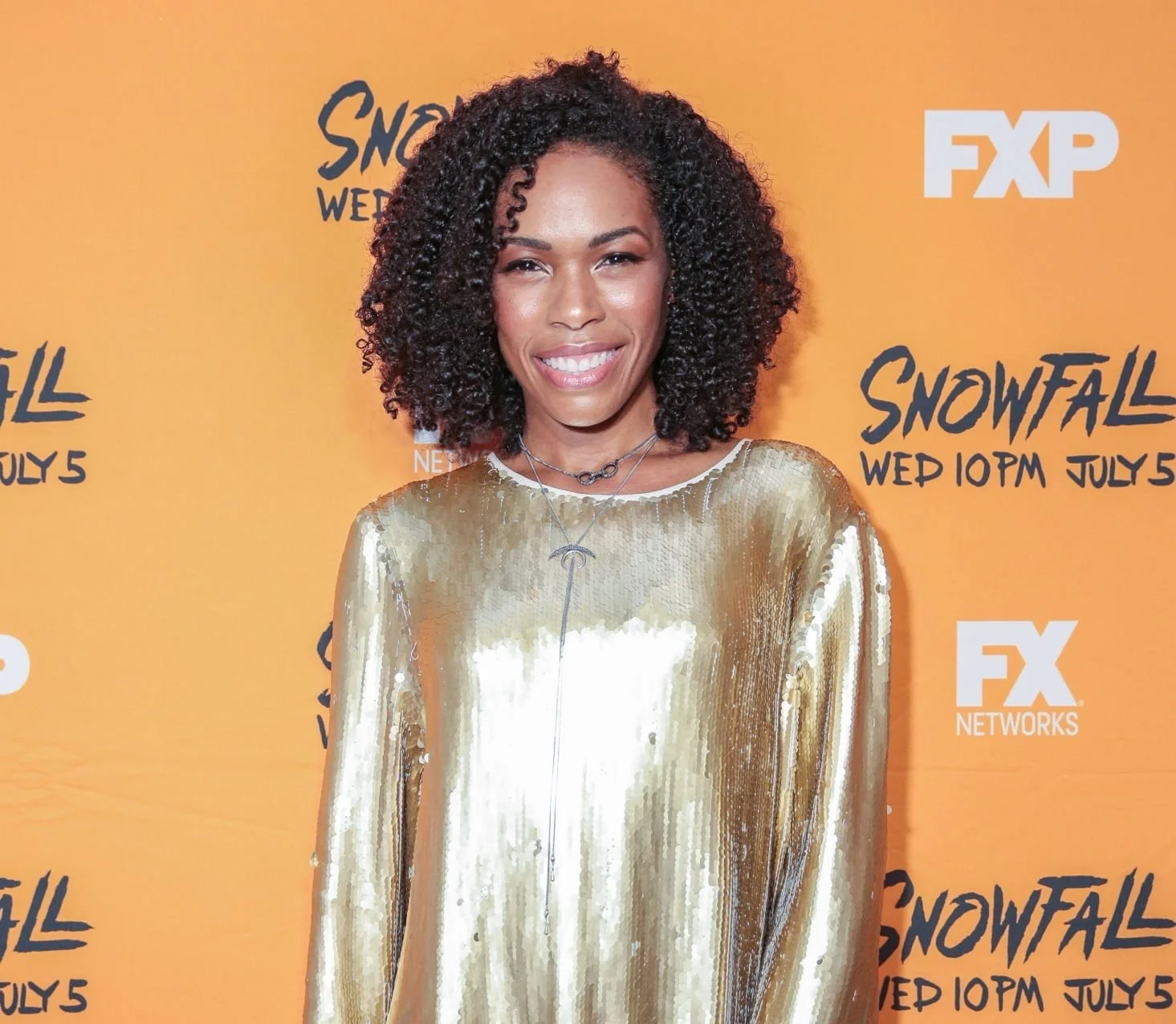 Actress Angela Lewis on the red carpet premiere for Snowfall, wearing a gold sequin shirt dress, styled by Chandra Moore.