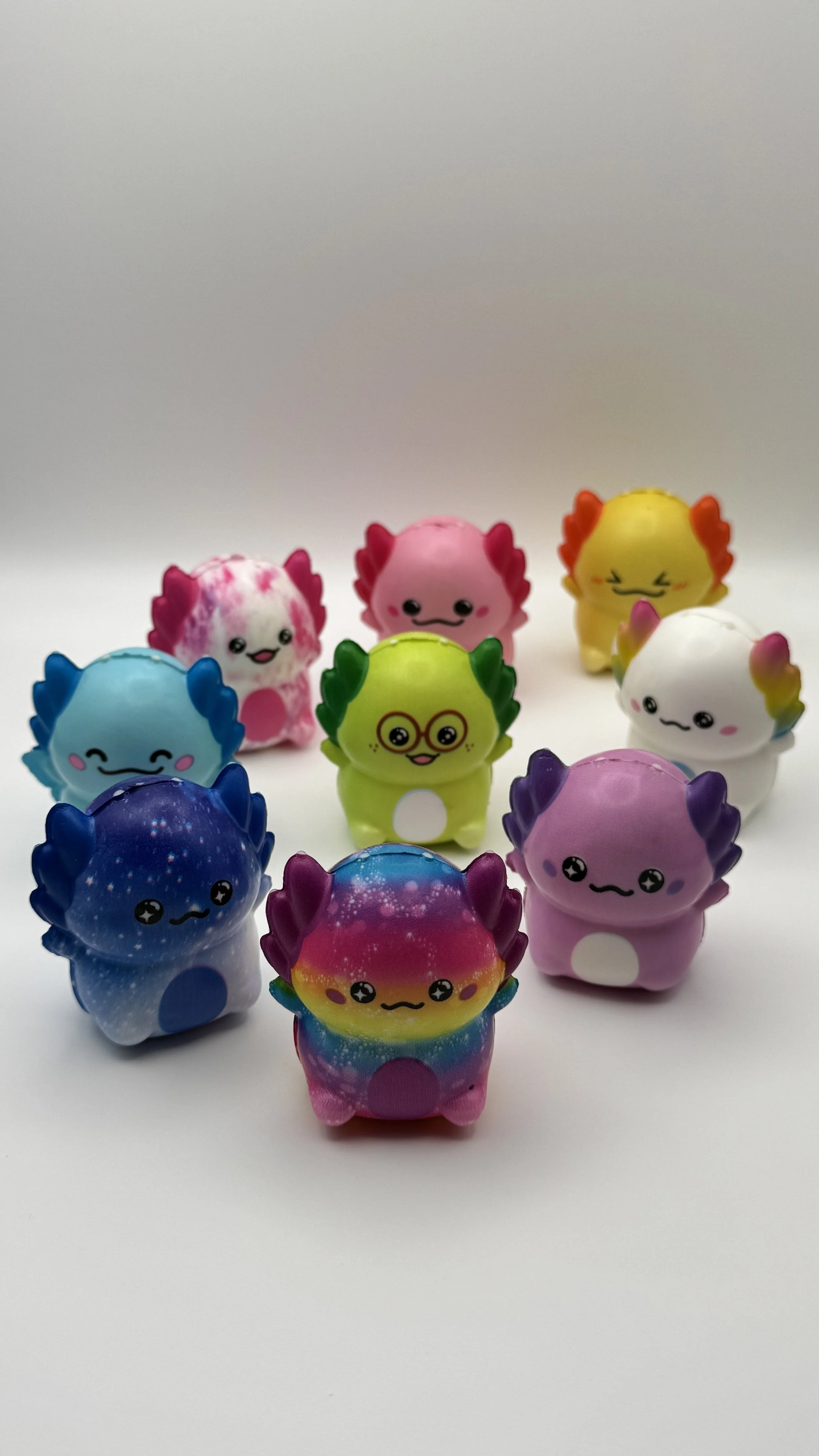 Collection of colorful, cartoon-style dinosaur toys arranged on a white surface with a plain background.