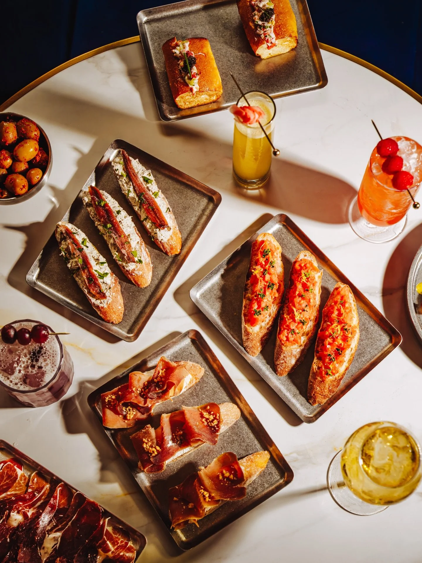 A table meant to be shared. ✨🧜&zwj;♀️

Conservas, jam&oacute;n, pan con tomate, and cocktails poured to match &mdash; bold flavors, simple ingredients, and plates that keep coming. This is how we do it at Seirēn.

#SeirenNYC #Conservas #TapasNYC #NY