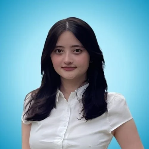 A young woman with long dark hair wearing a white blouse against a solid light blue background.