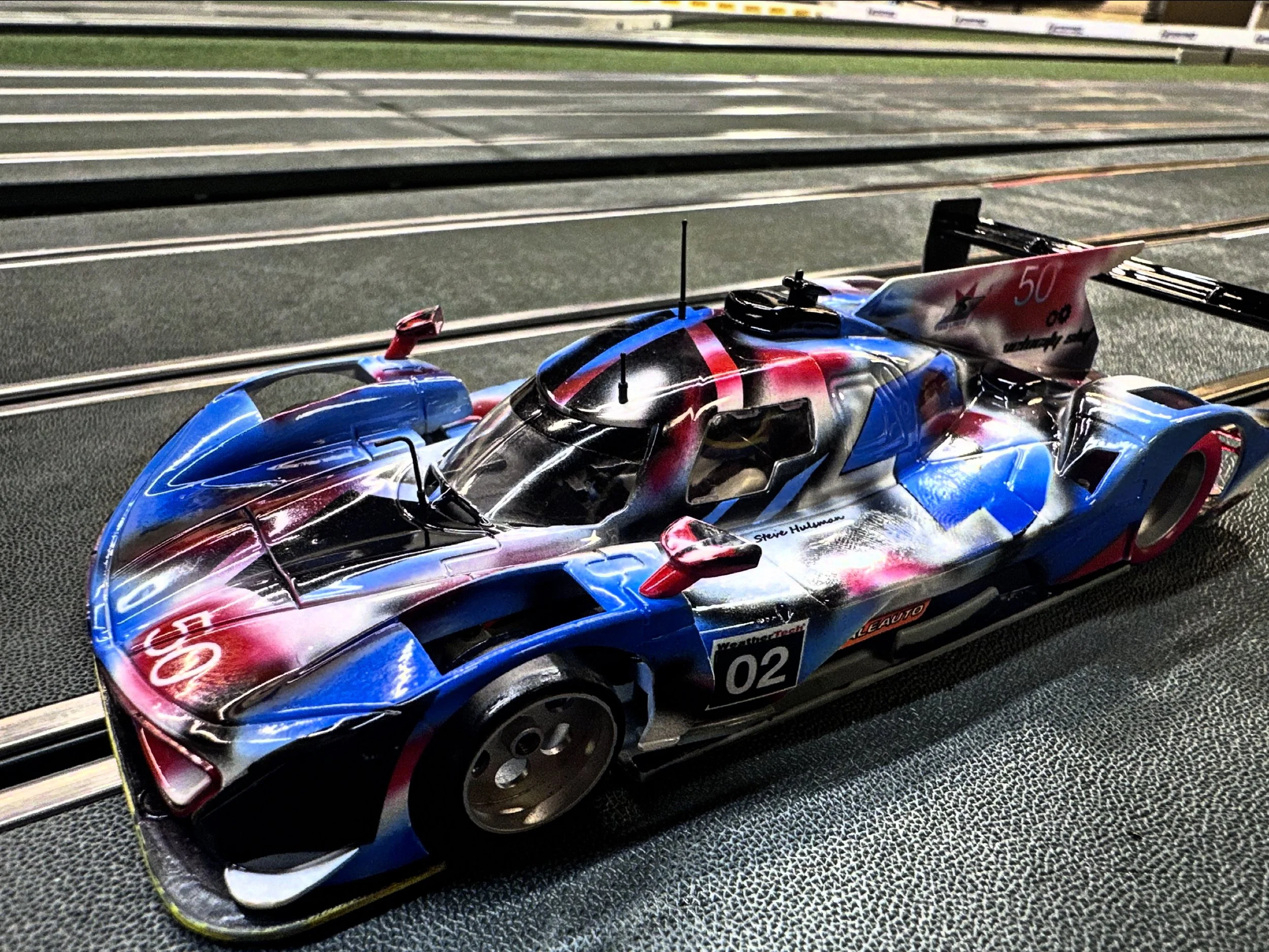 A detailed model of a racing car on a slot car track.