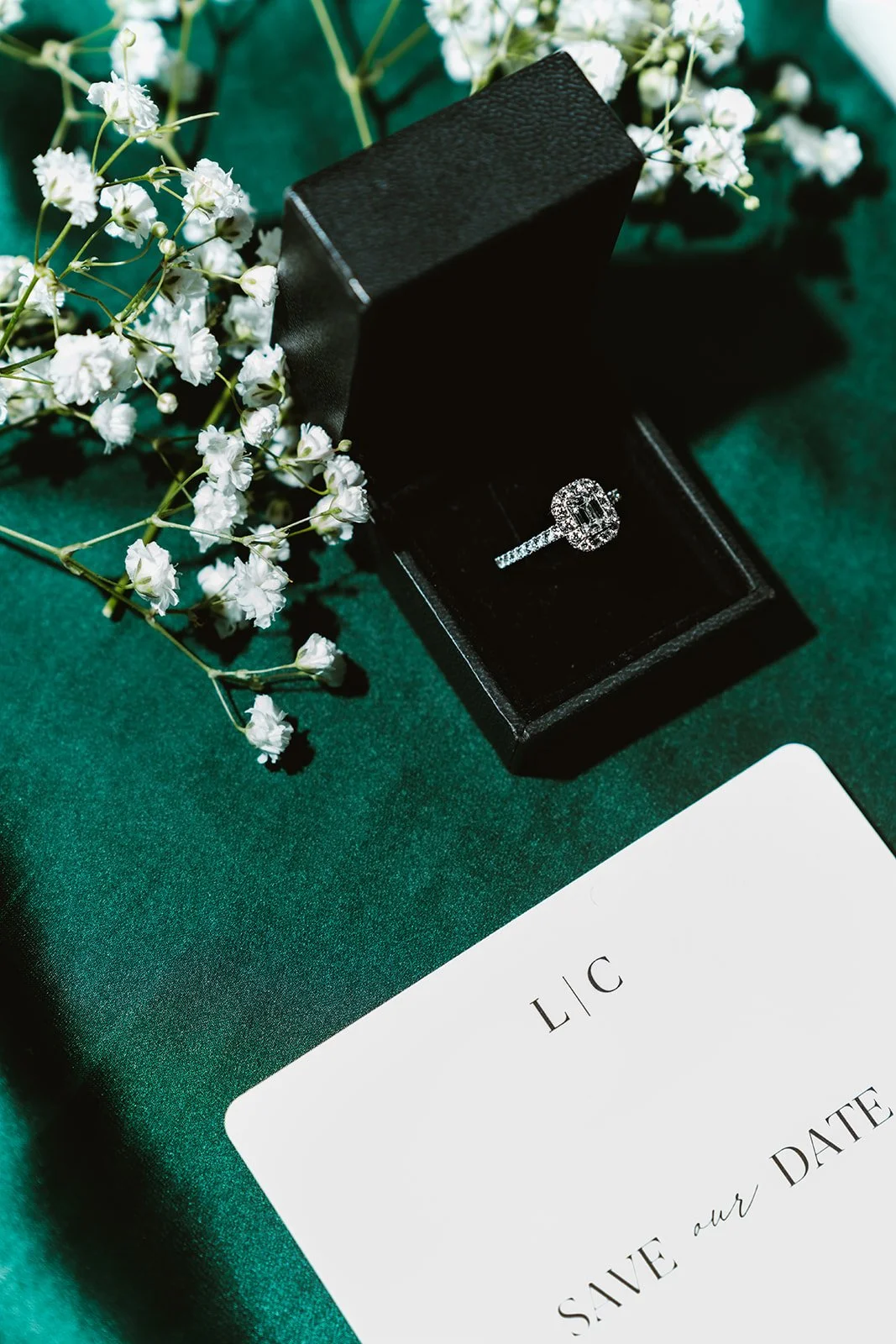 Save-the-Date-Karte mit Verlobungsring und floralen Hochzeitsdetails.
