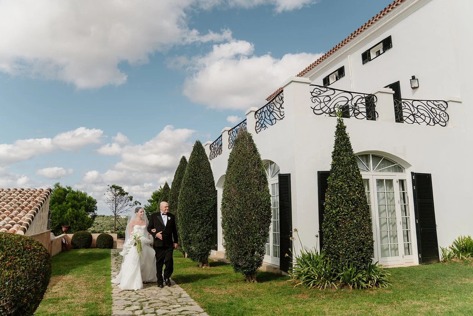 Bride walking to ceremony with her father at finca wedding in Menorca