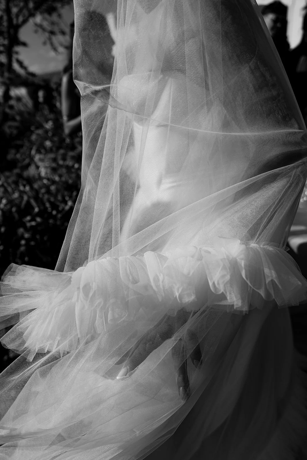 Close-up of a bridal gown and veil captured in soft light with an editorial, artistic feel