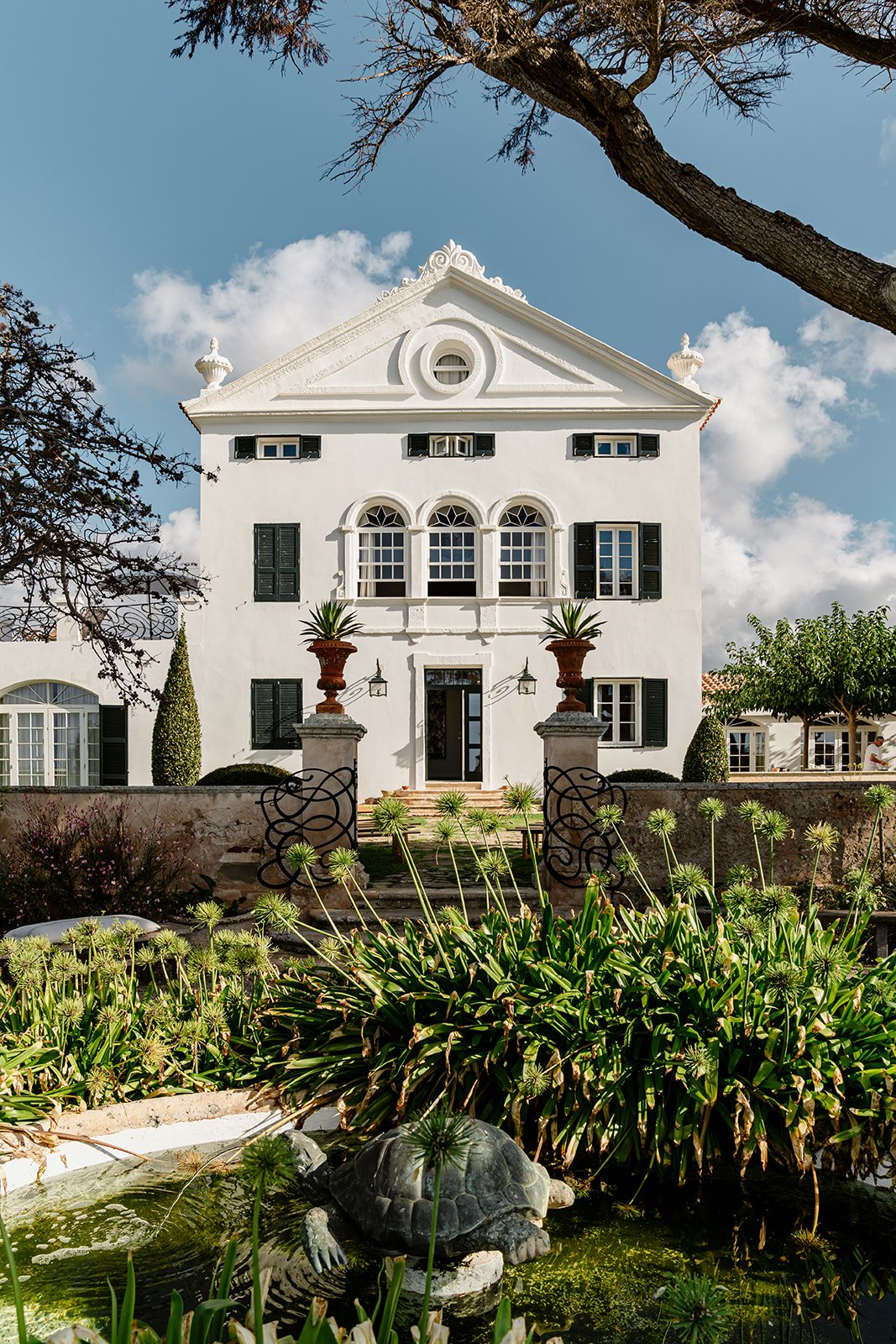 Elegant white Mediterranean villa surrounded by palm trees and garden, luxury wedding venue in Menorca