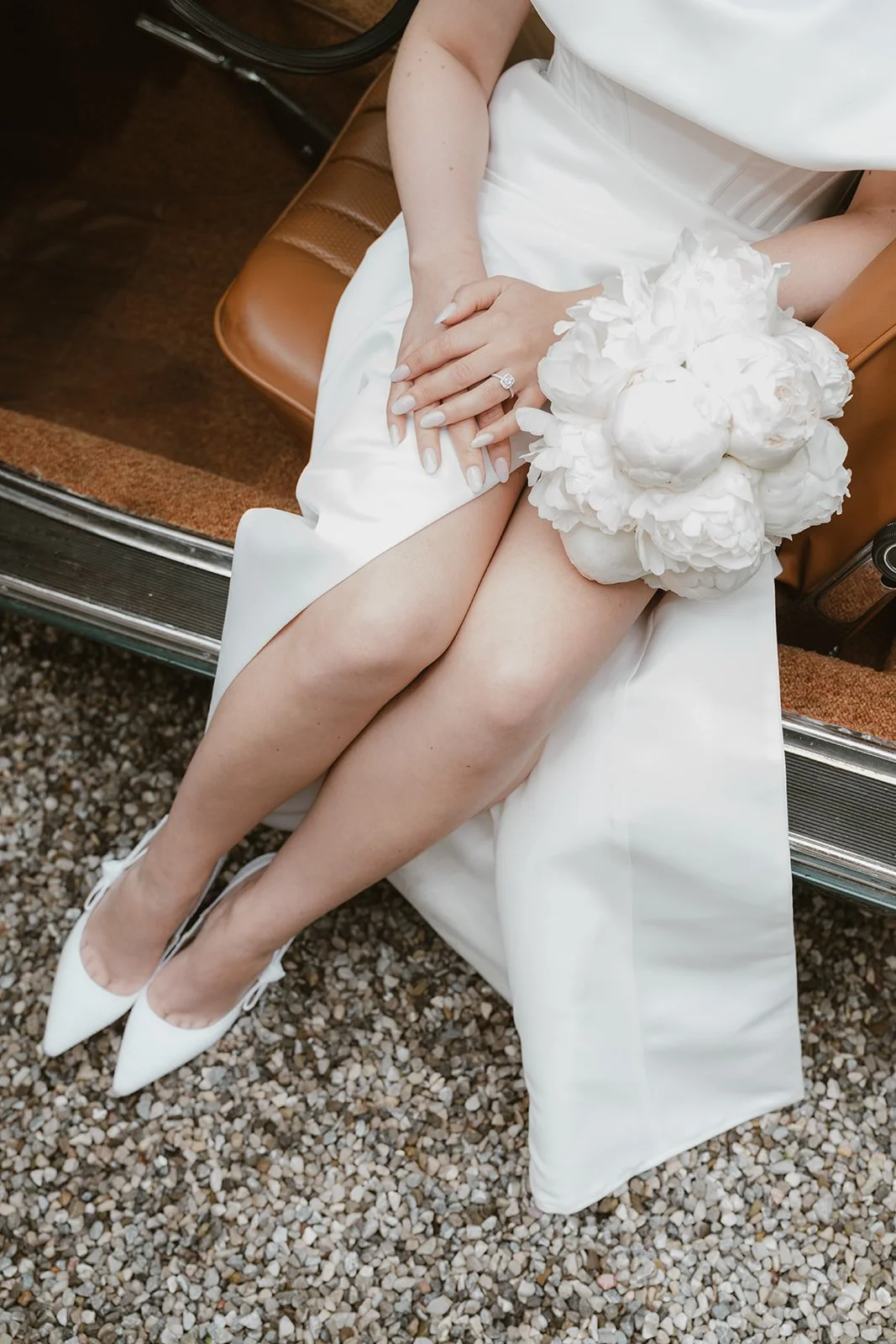 Detailaufnahme des Verlobungsrings der Braut mit weißem Brautstrauß während der Hochzeit.