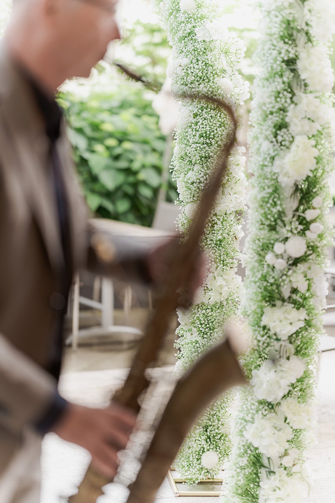 Saxophonist begleitet die freie Trauung vor einer floralen Zeremoniedekoration im Hotel Lengbachhof.