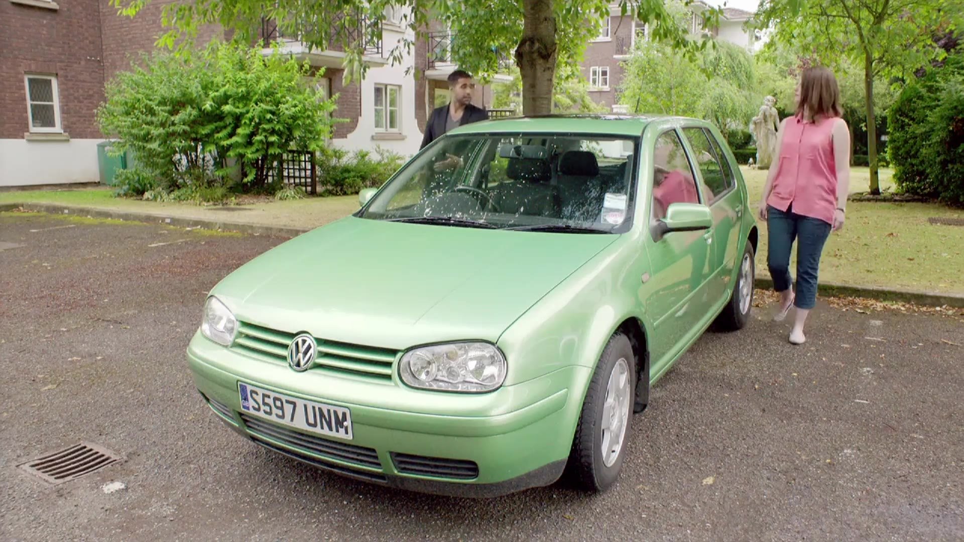 Woman walking past a green car before a test drive, from a Tempcover advert