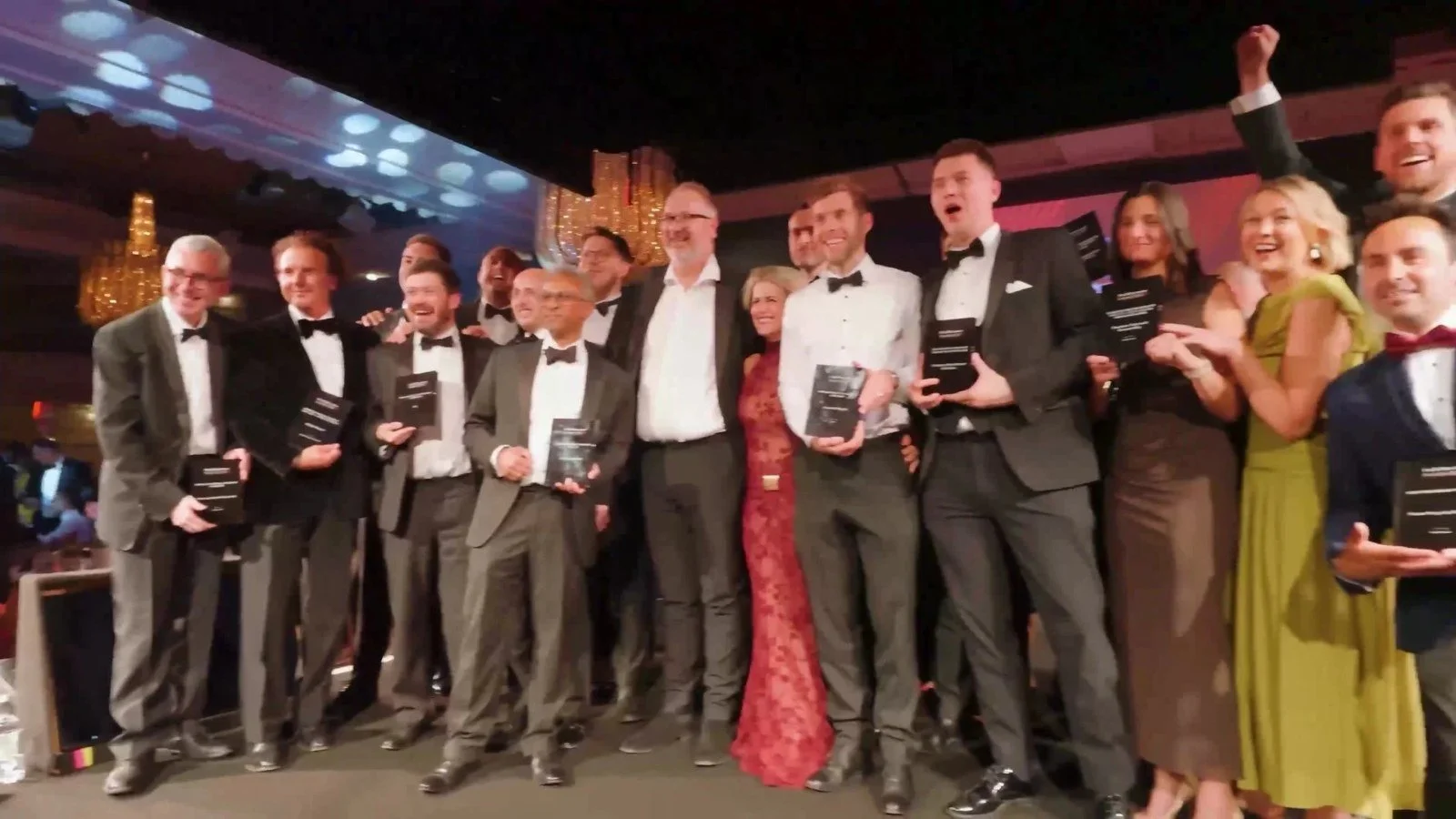 Winning team celebrating with their awards on stage at the HealthInvestor Awards