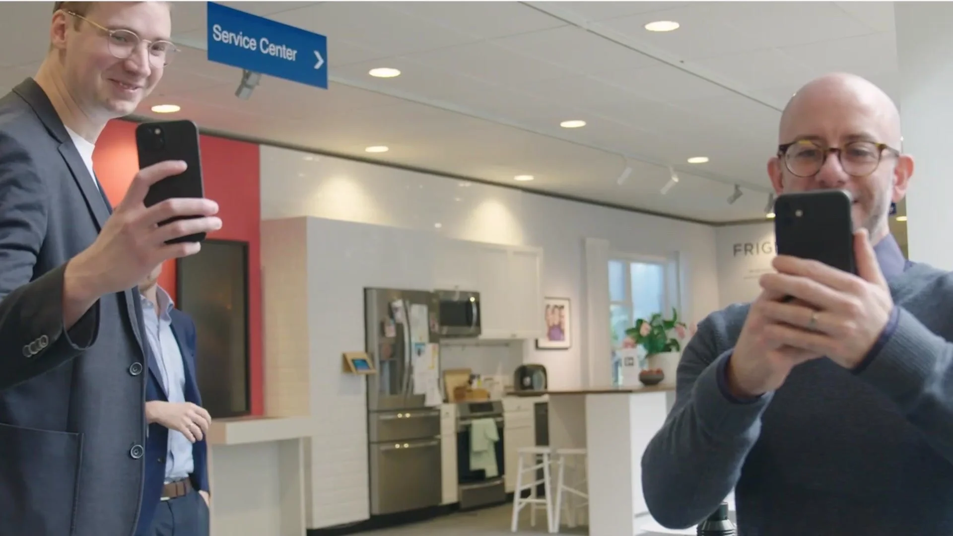 Electrolux team members filming on their phones in a service centre