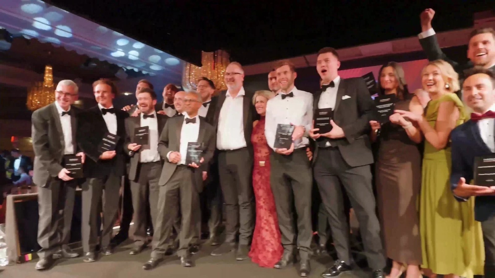 Winning team celebrating with their awards on stage at the HealthInvestor Awards