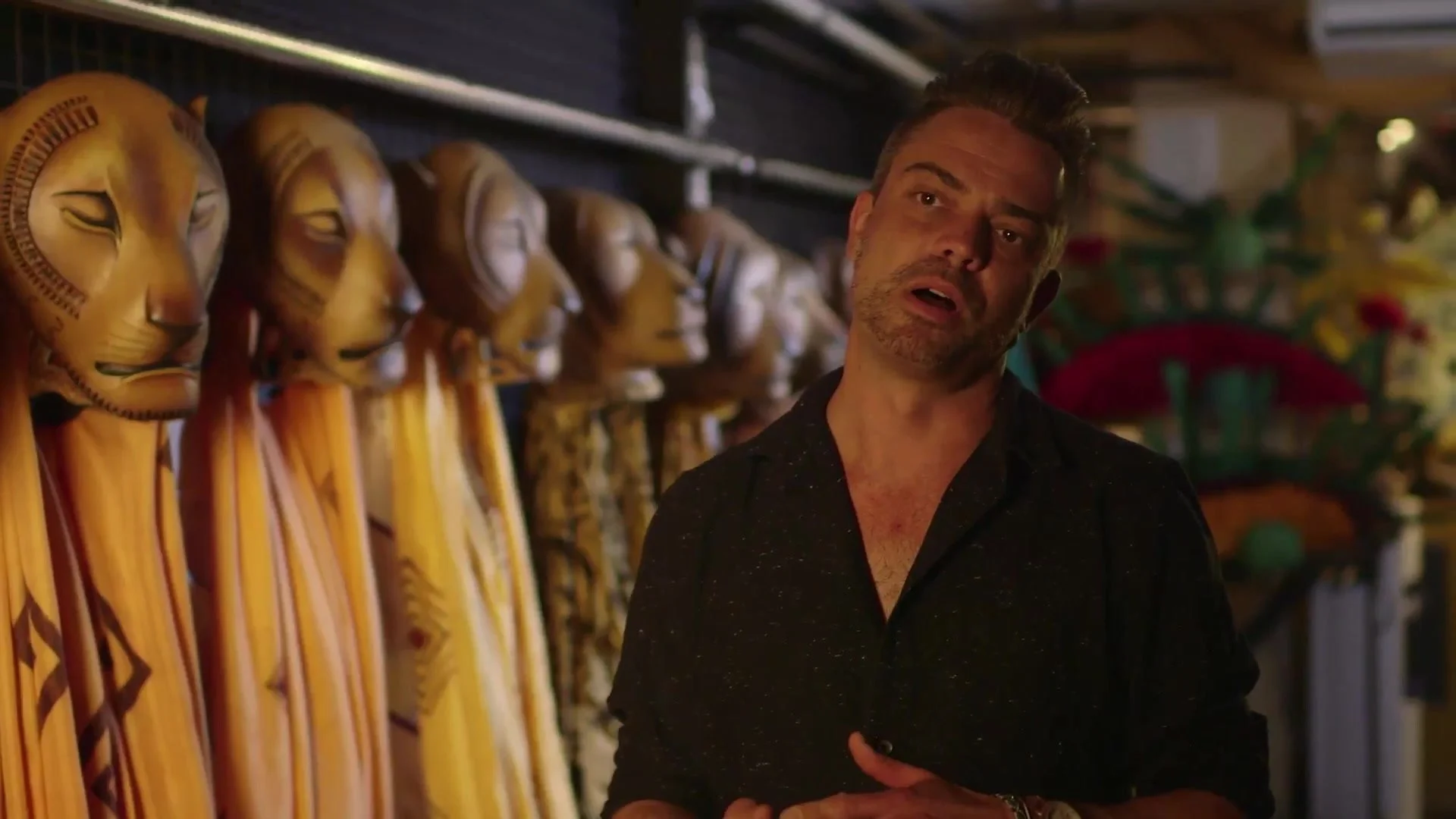 Matt Clarke, Head of Wardrobe, beside a row of lion masks backstage at The Lion King