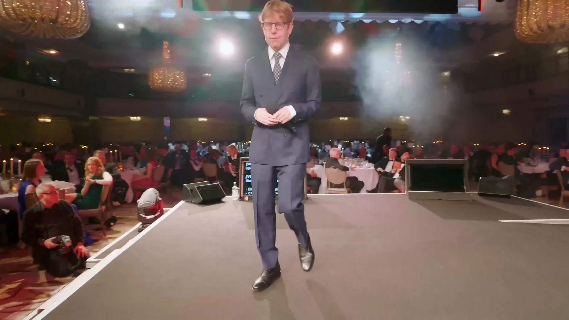 Host walking the stage at the HealthInvestor Awards ceremony