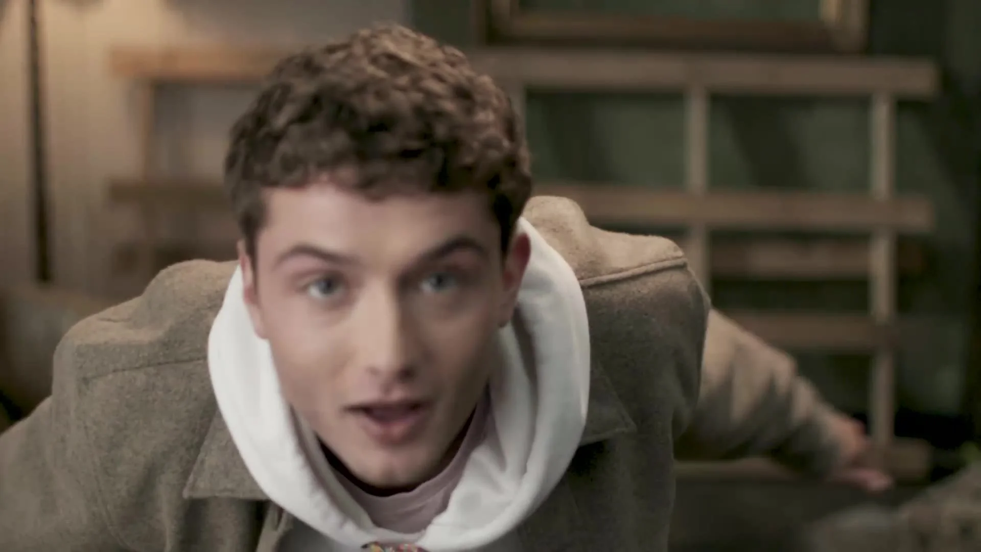 Character in a hoodie leaning towards the camera
