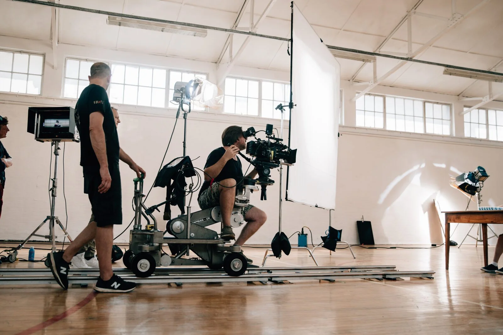 A camera on a dolly track in a daylight studio