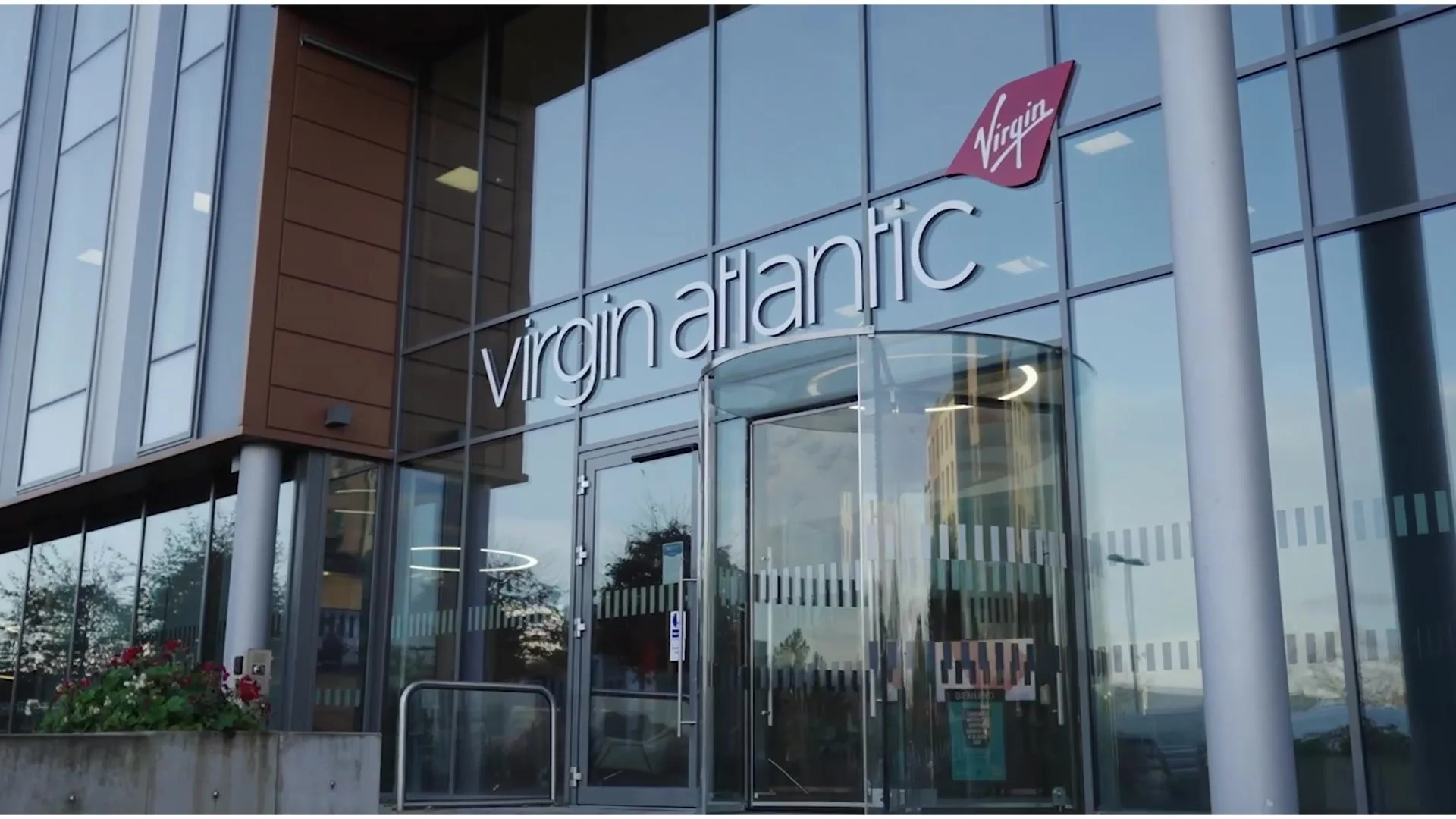 Virgin Atlantic sign and logo on the glass entrance of its offices, from the Genesys case study video