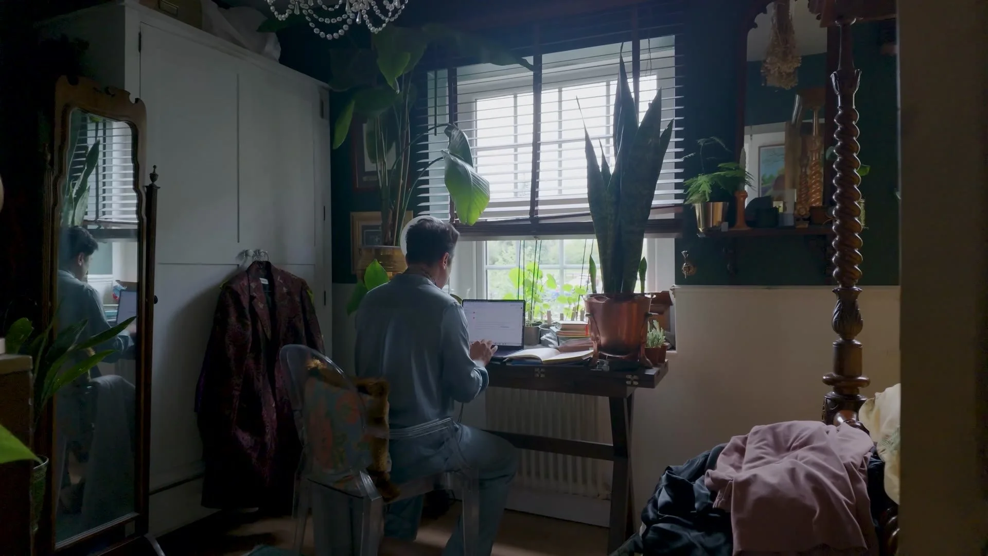 Kamal Kaan writing at his desk by the window