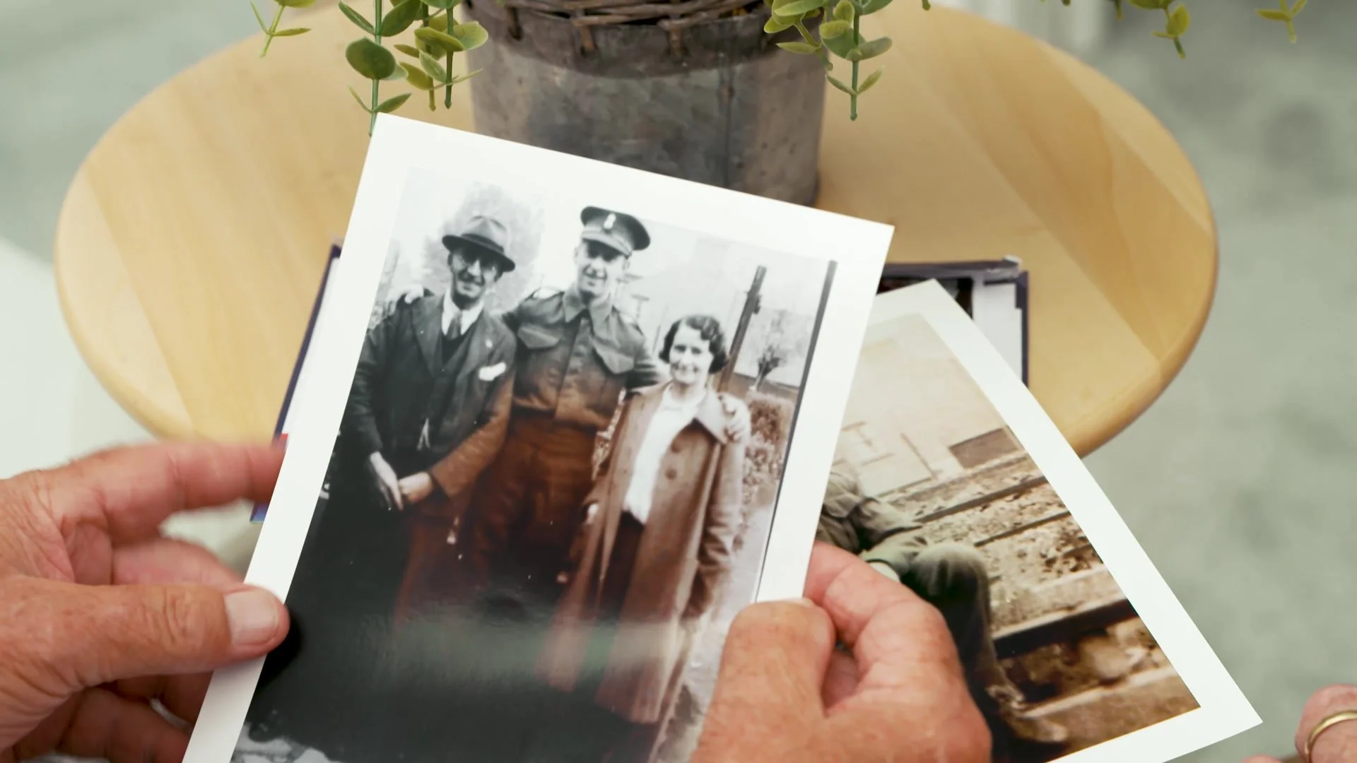 Hands holding a wartime family photograph