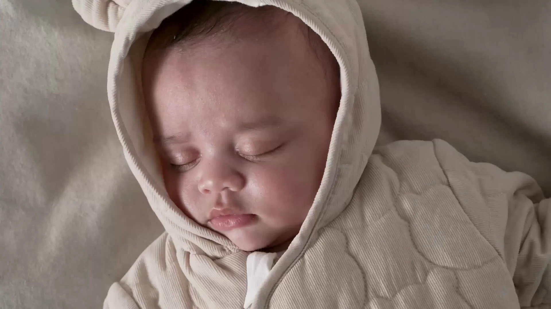 Sleeping baby in a hooded romper, from a Mothercare product video