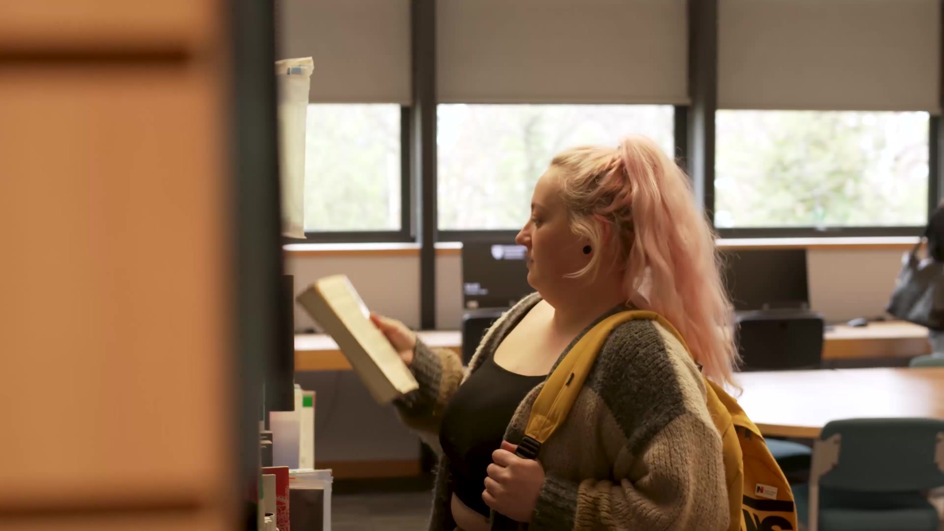 A student choosing a book in the library