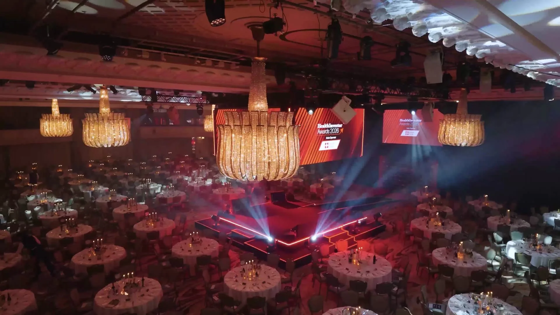 Ballroom dressed with stage lighting and chandeliers for the HealthInvestor Awards