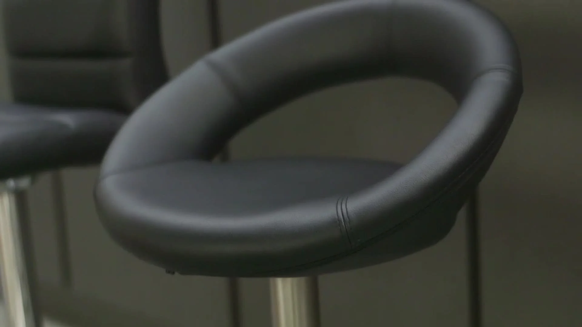 A curved bar stool seat in close-up