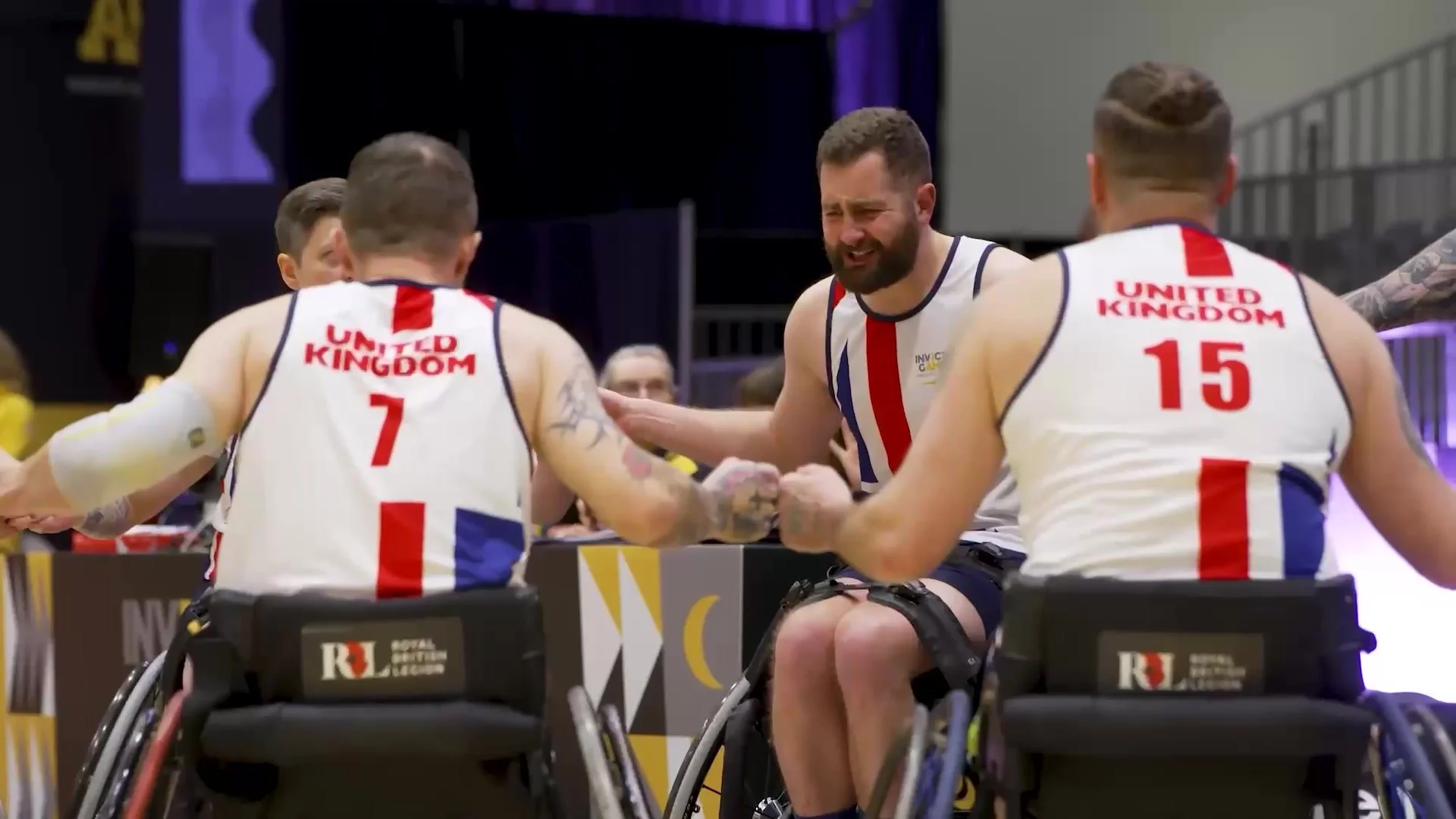 UK wheelchair basketball players in Royal British Legion colours celebrating together