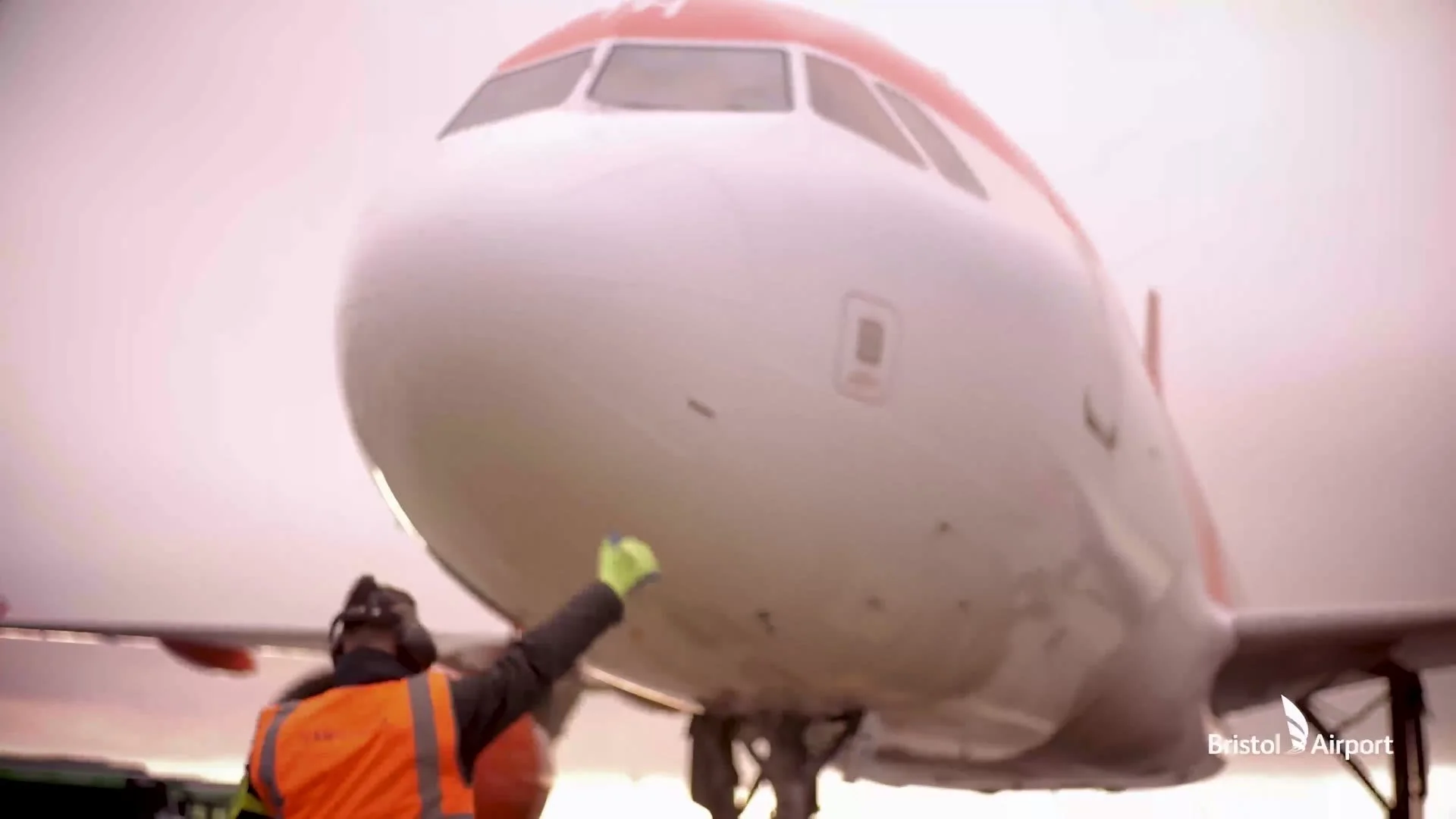 Ground crew guiding an aircraft at Bristol Airport