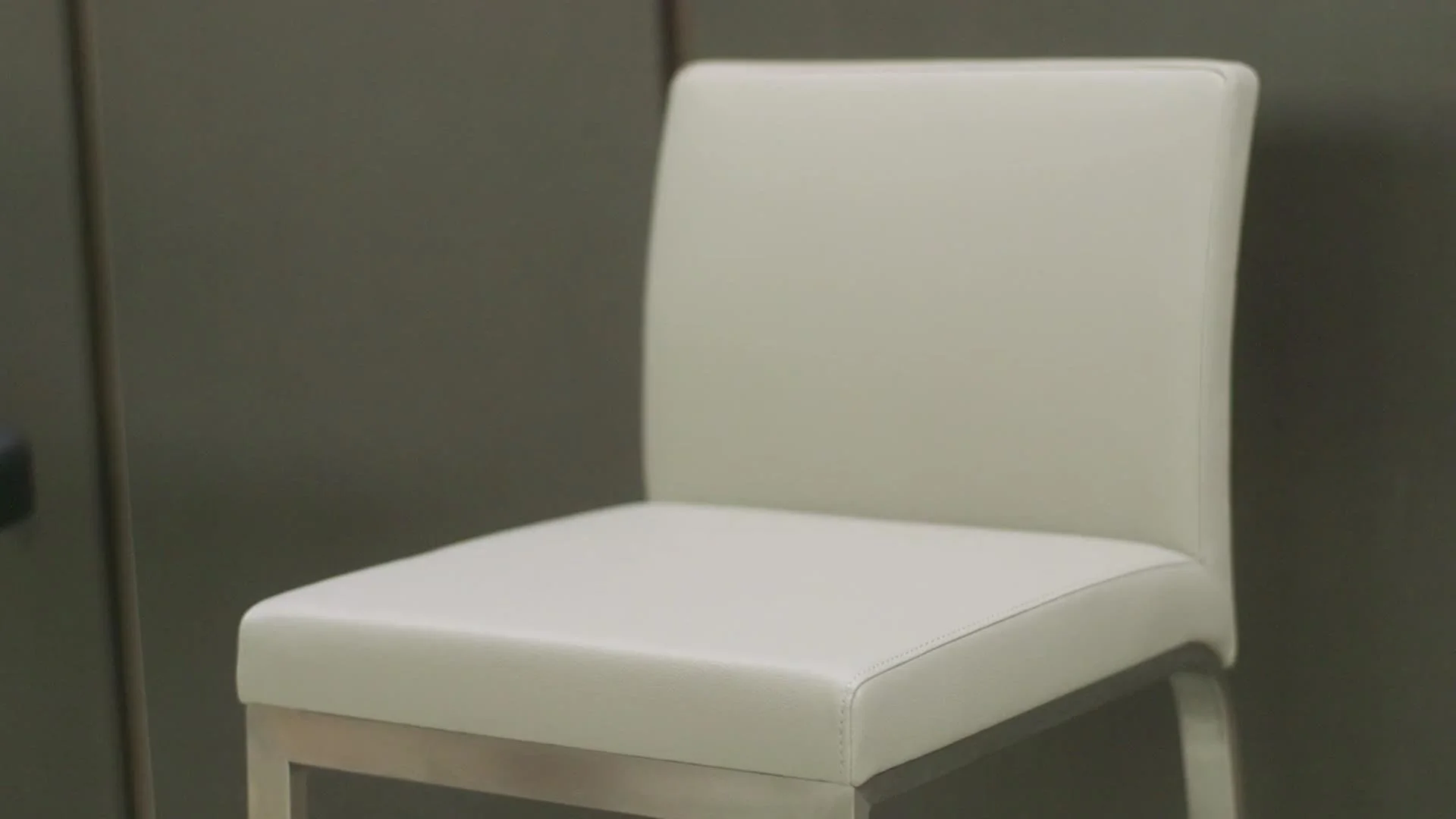 A cream fixed-height bar stool