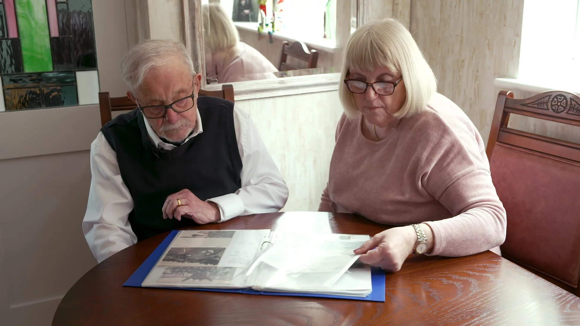 Alan Kennett looking through his photo album with family