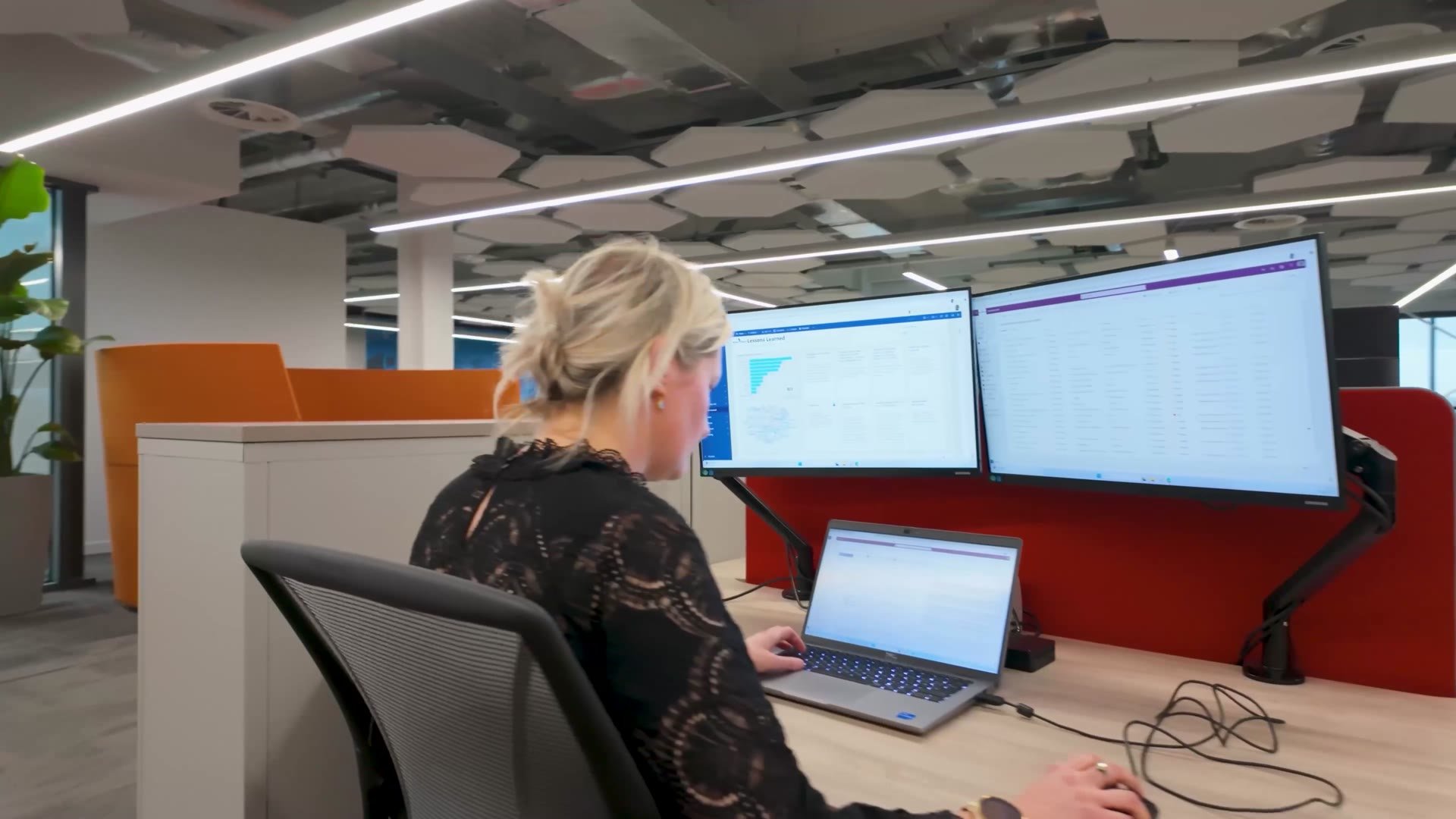 Head of PMO reviewing project dashboards at her desk
