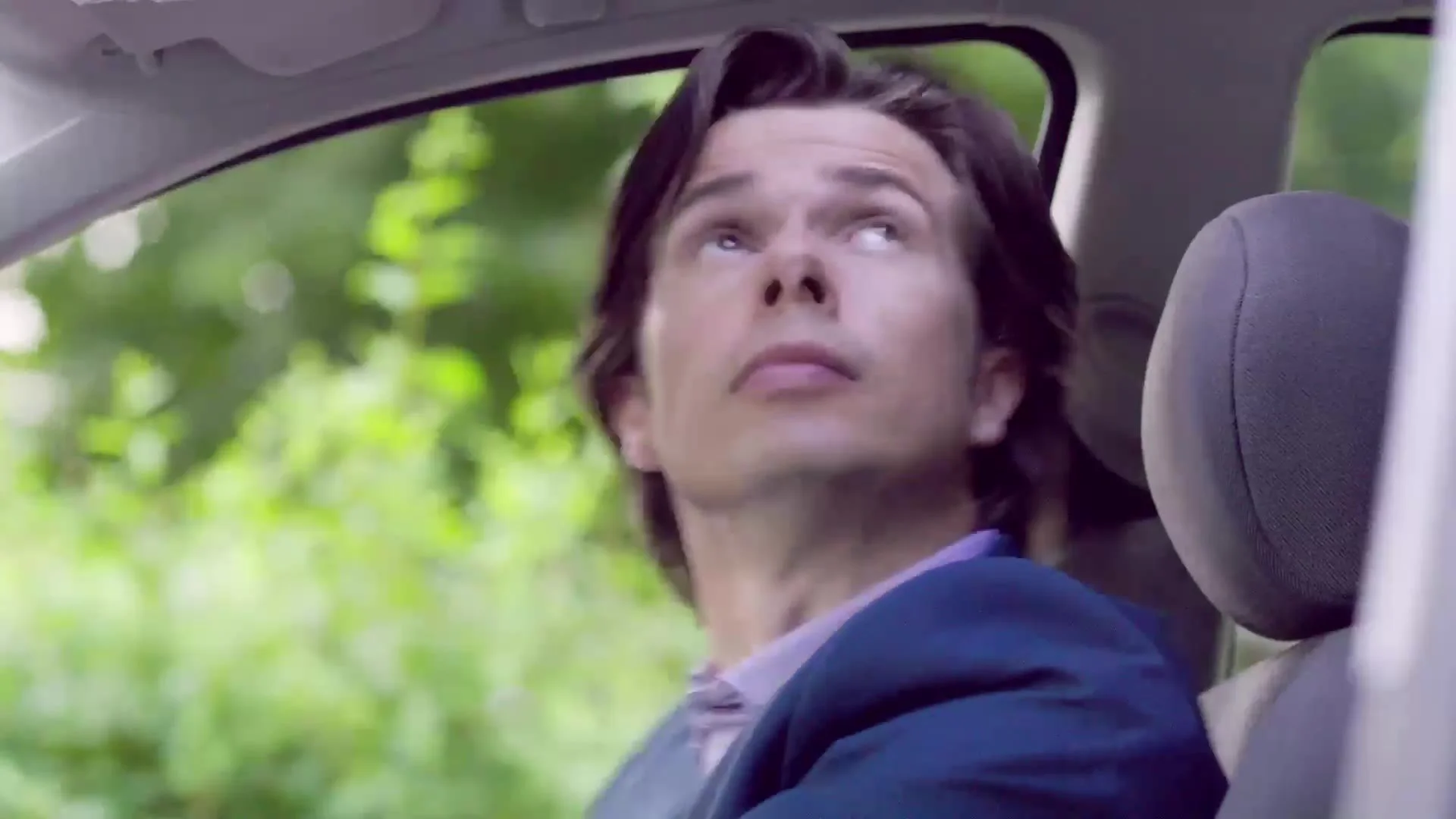 Driver looking up in alarm from inside a car, from a Tempcover advert
