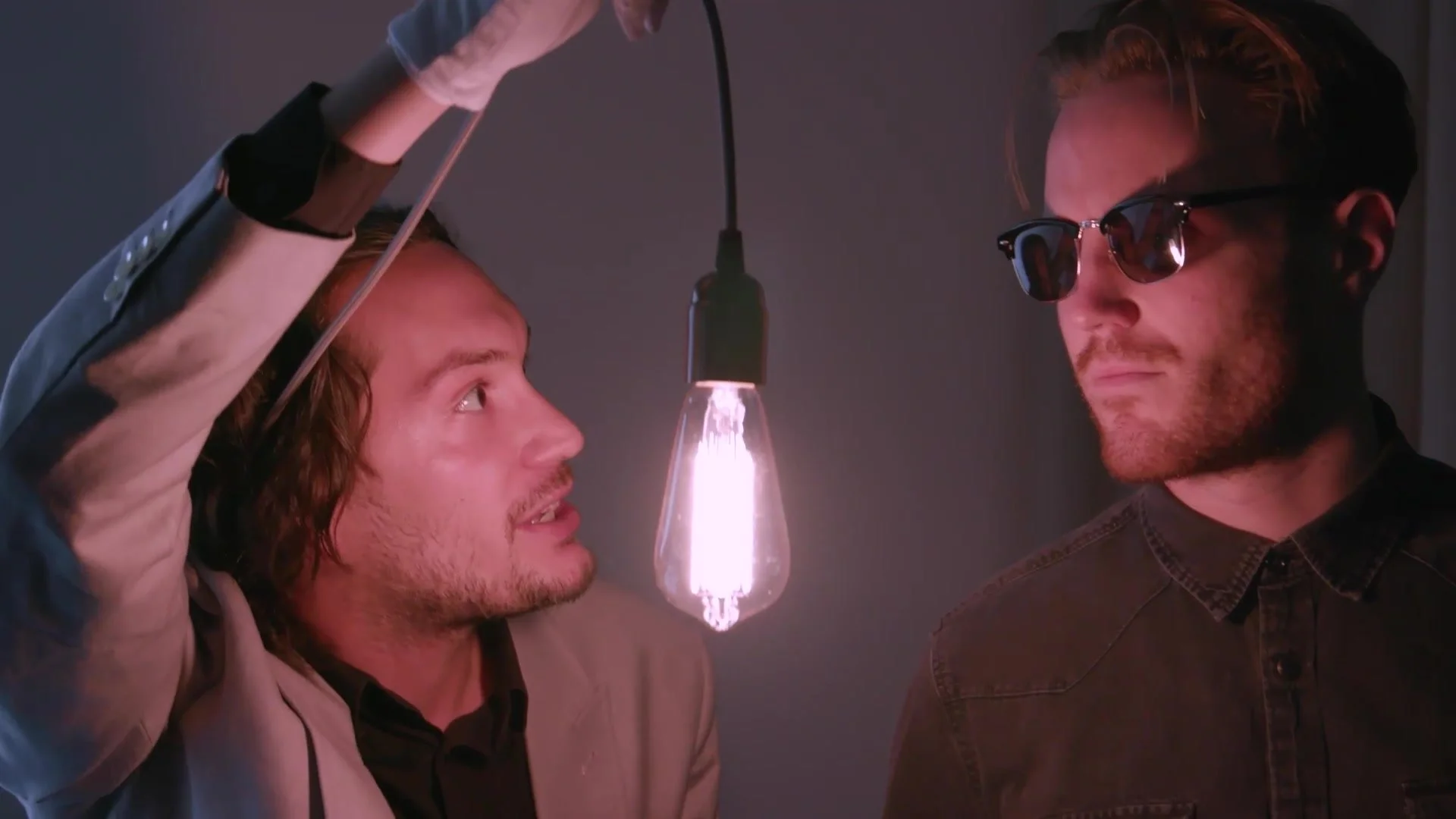 Two performers in a scene lit by a single bulb