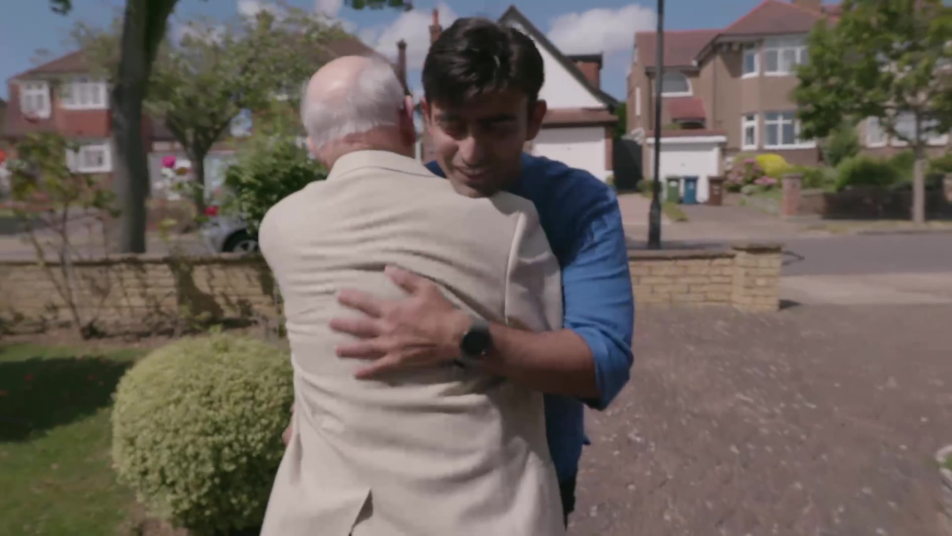Older man greeting his volunteer driver with a hug