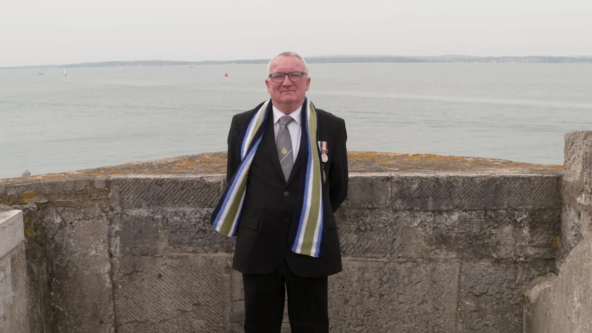 A Royal Navy veteran standing on the sea wall