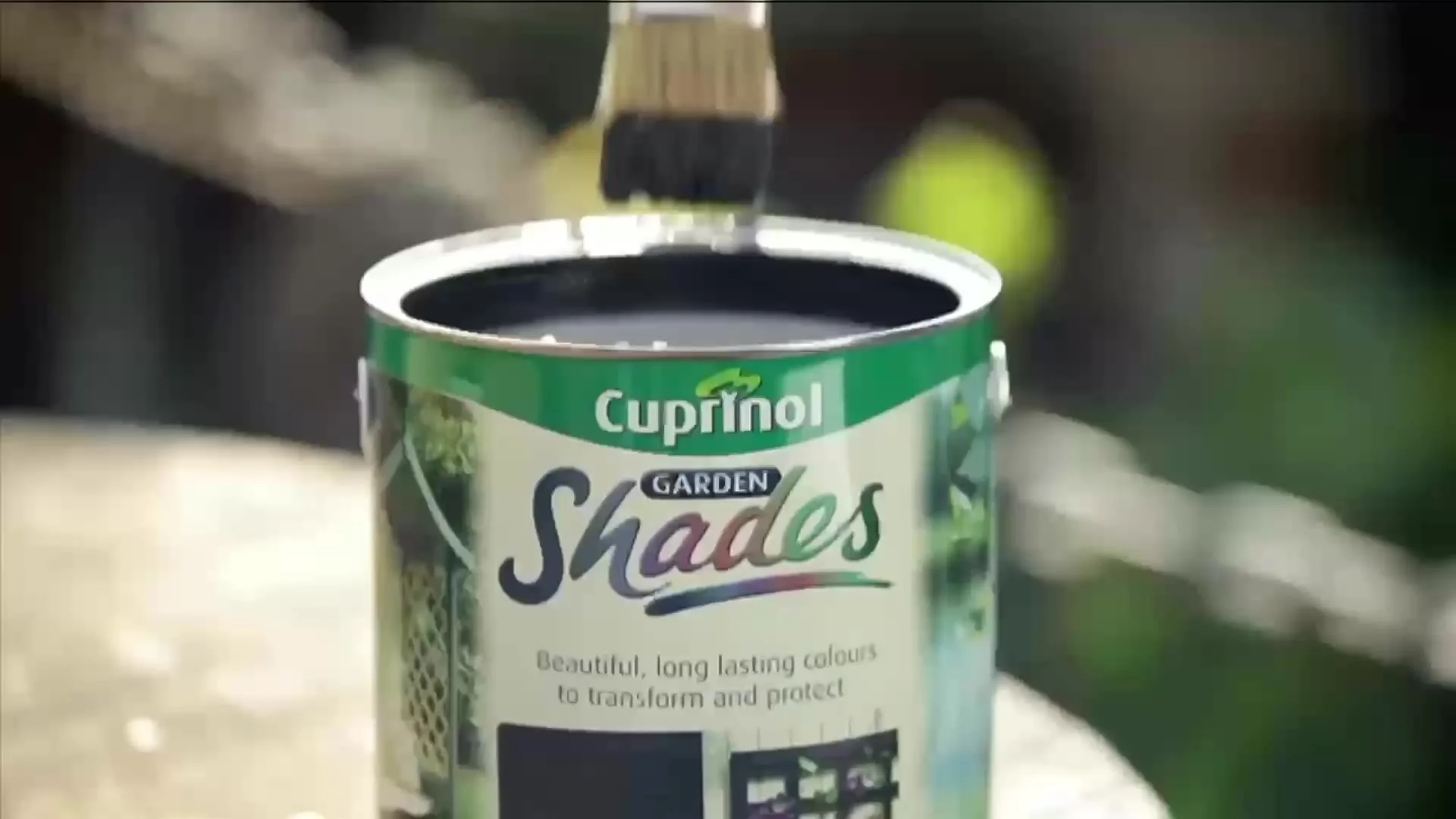 A brush in a tin of Cuprinol Garden Shades
