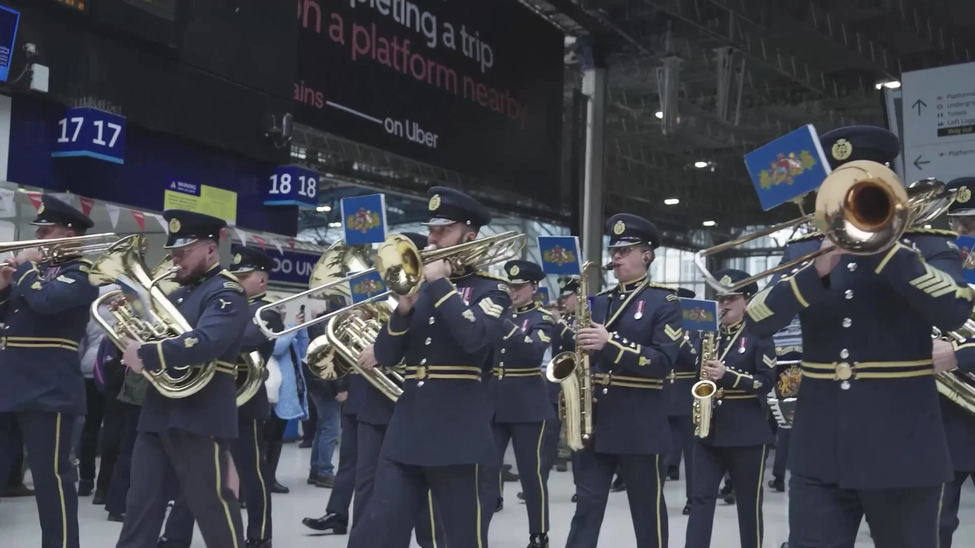Military band marching through a railway station for the Poppy Appeal