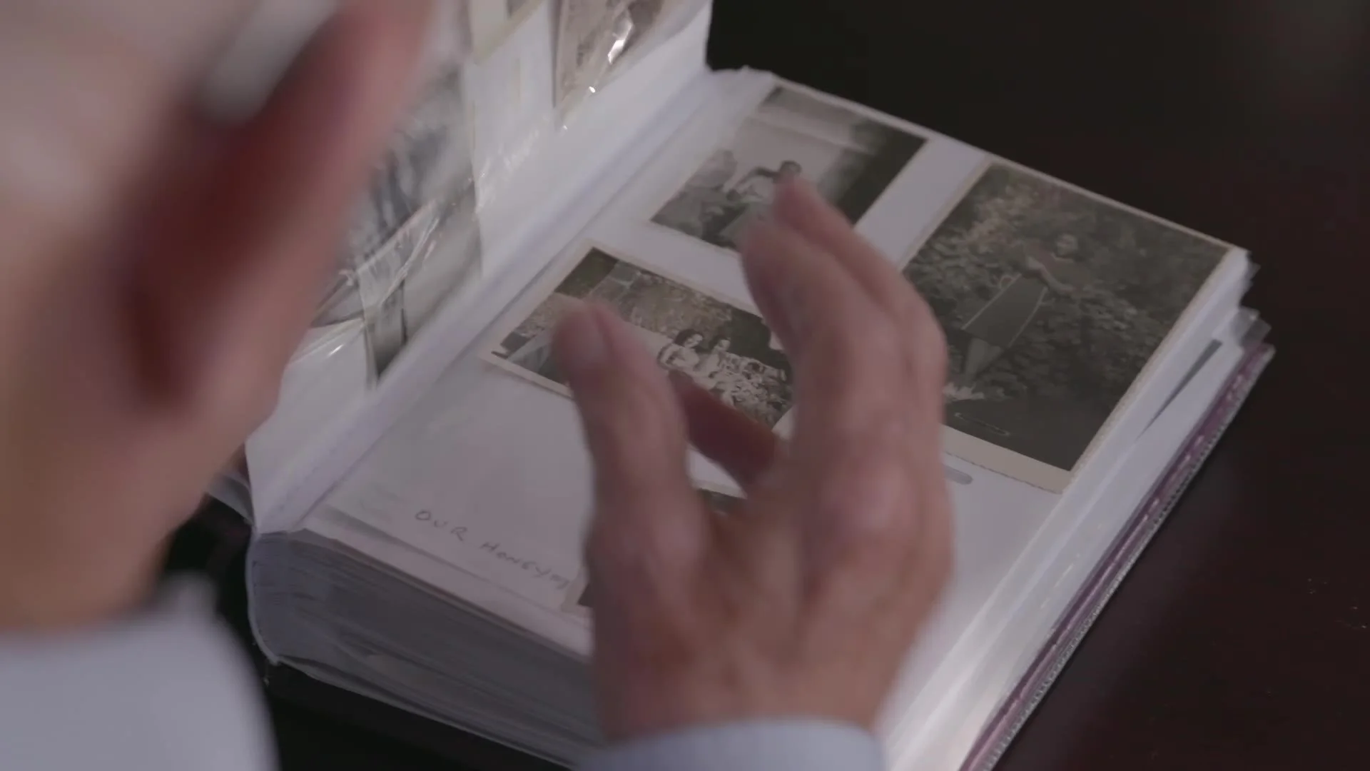 Hands turning the pages of a photo album