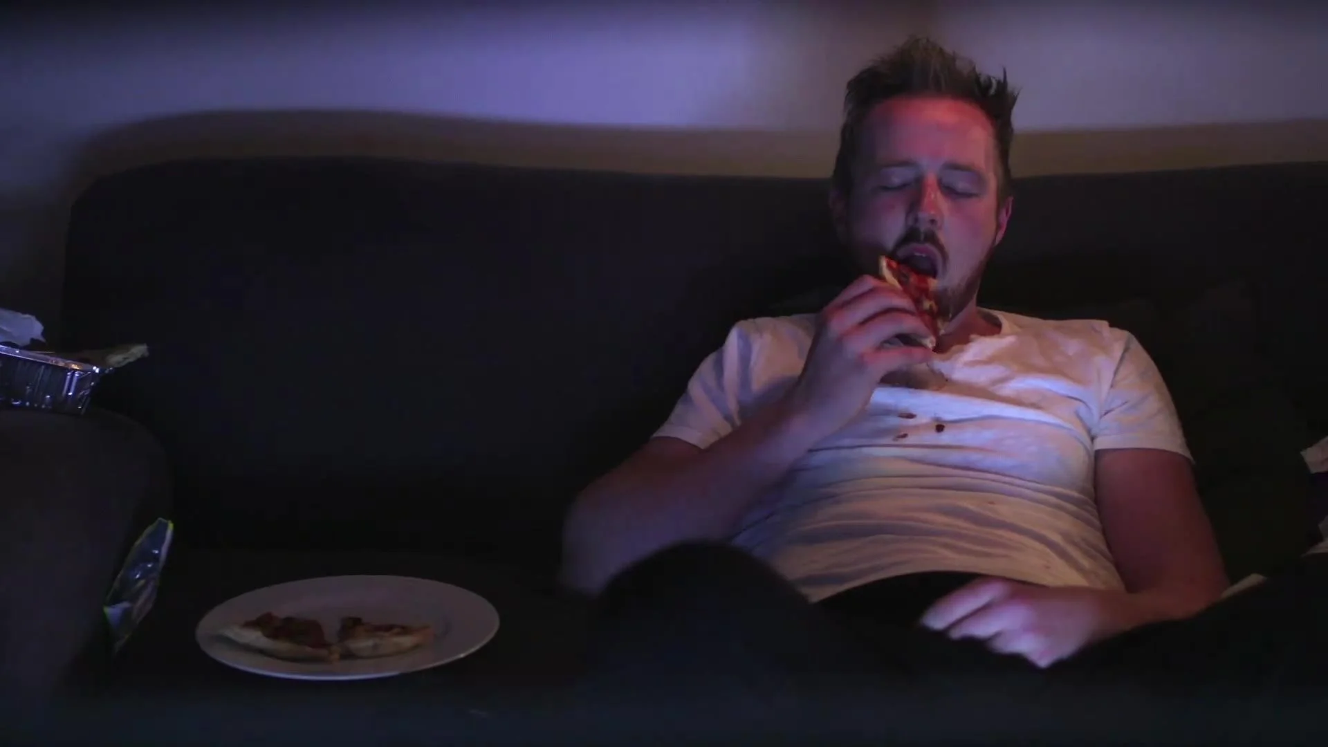 Man snacking on the sofa, from the MaxiNutrition Munchies ad
