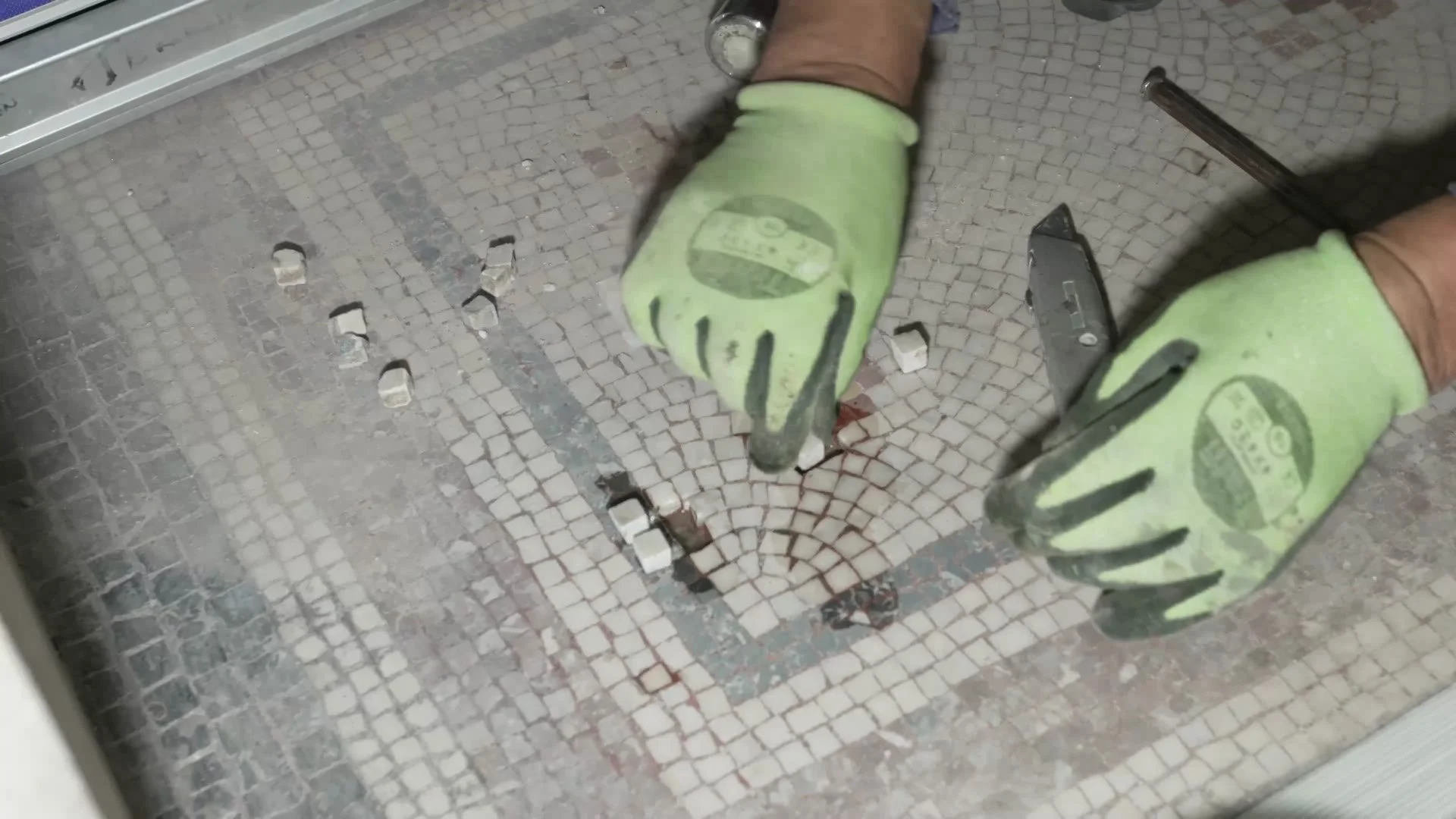 Repairing a mosaic floor tile by tile